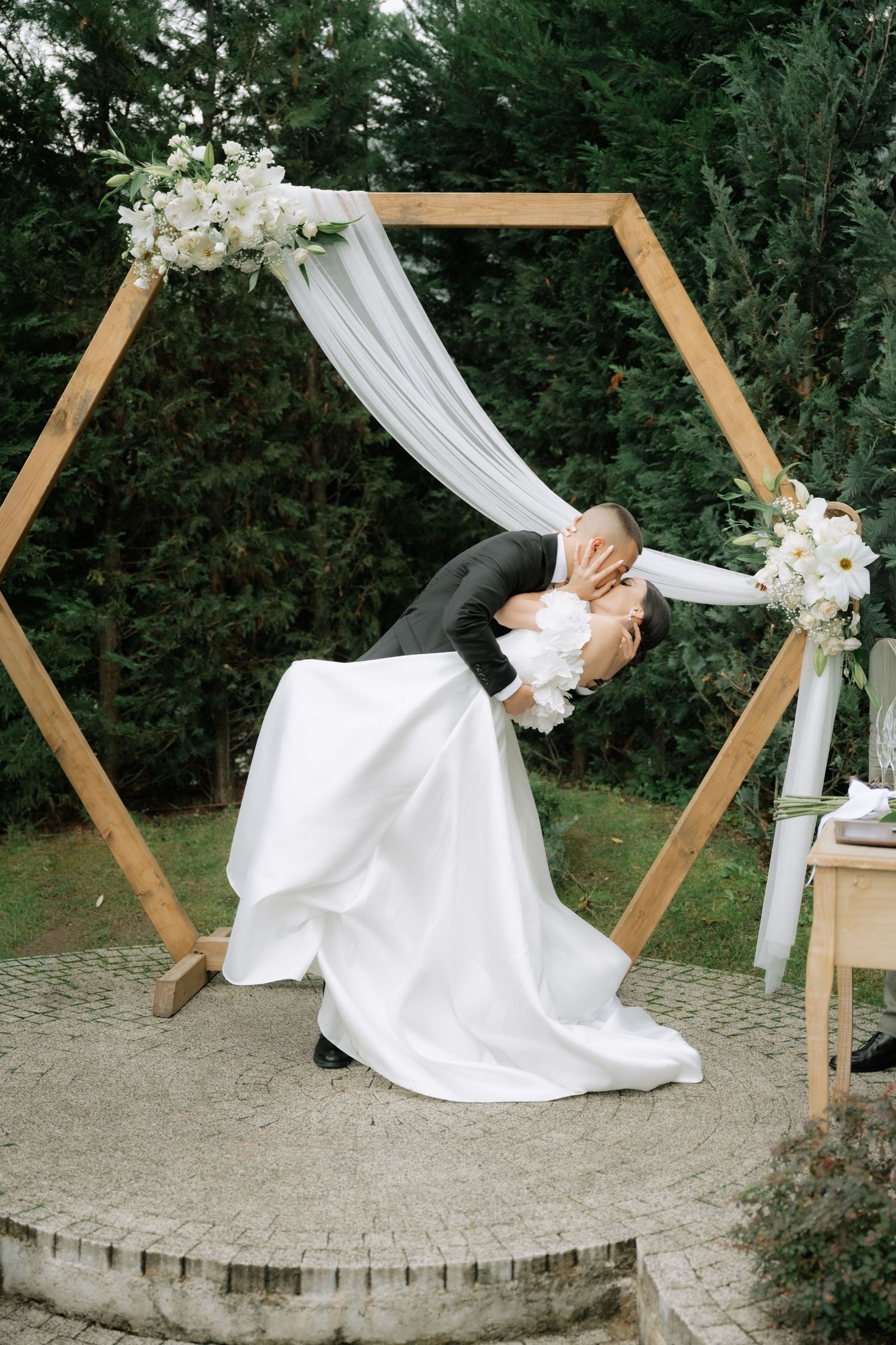 A sequence of artistic wedding photos showing a white dress flowing in a circular motion against a wooden arch backdrop.