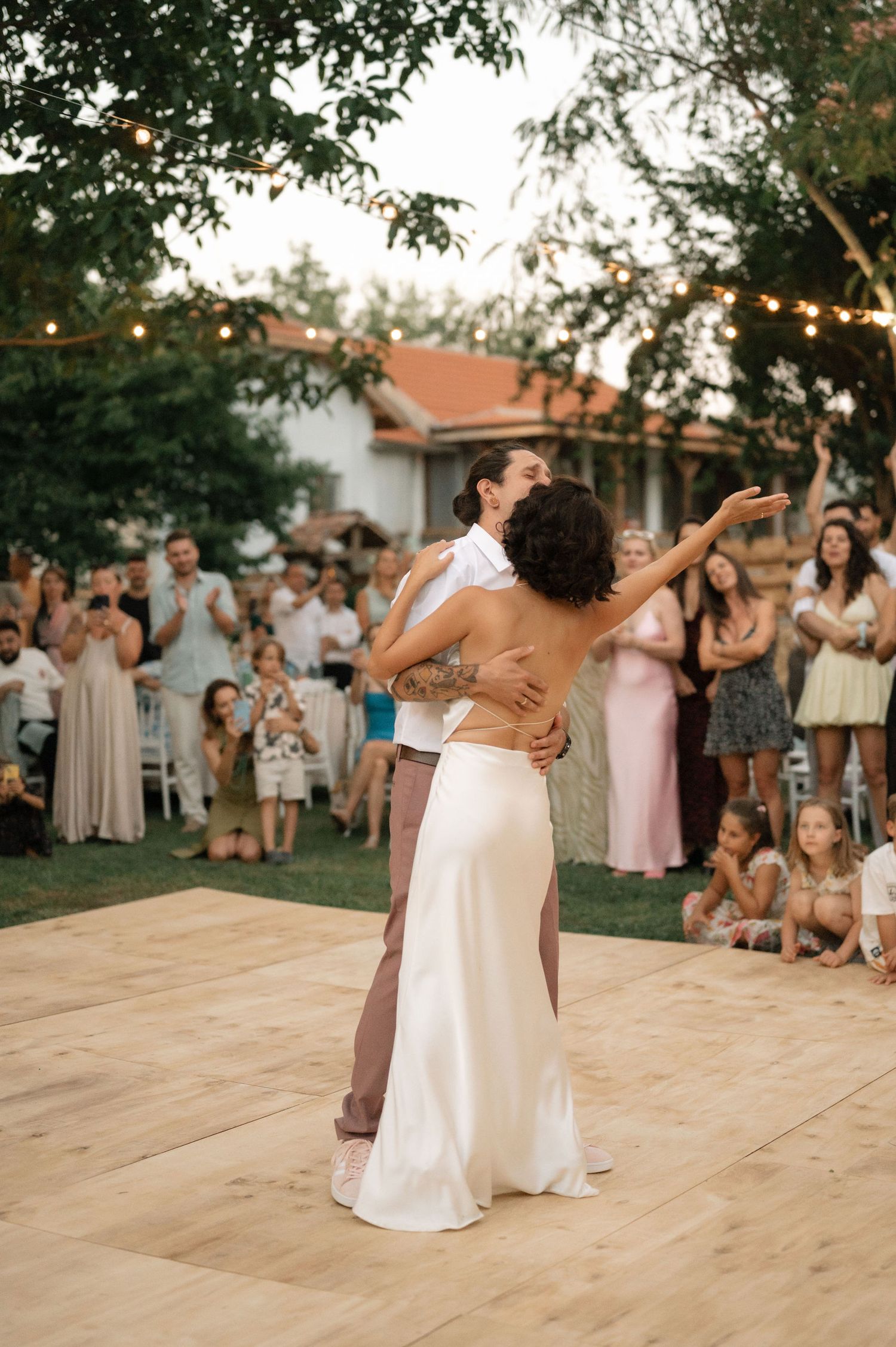 A series of dance photos showing a couple twirling and celebrating on a wooden dance floor at an outdoor wedding reception.