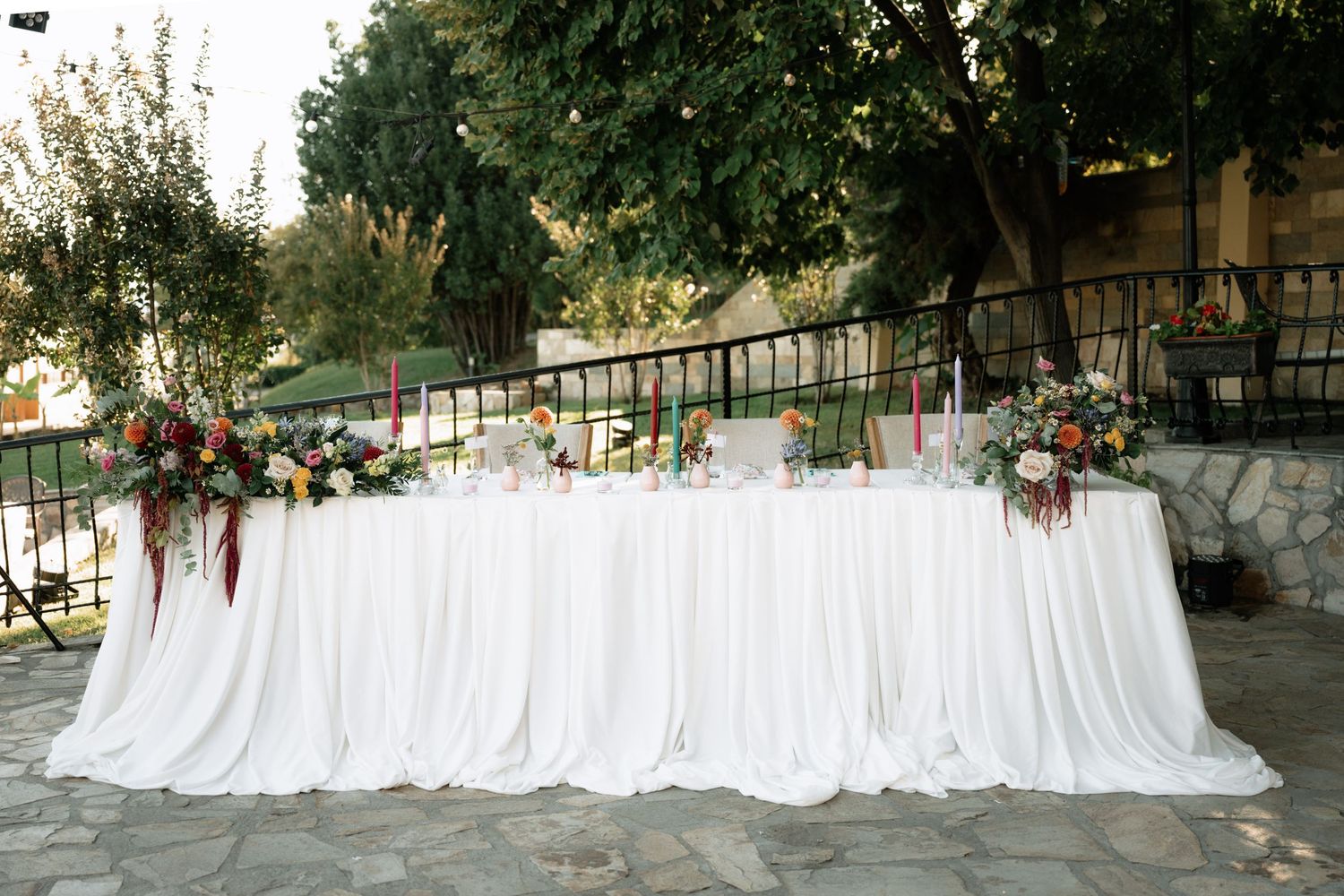 White fabric drapes elegantly across a rustic outdoor setting creating an ethereal wedding ceremony backdrop.