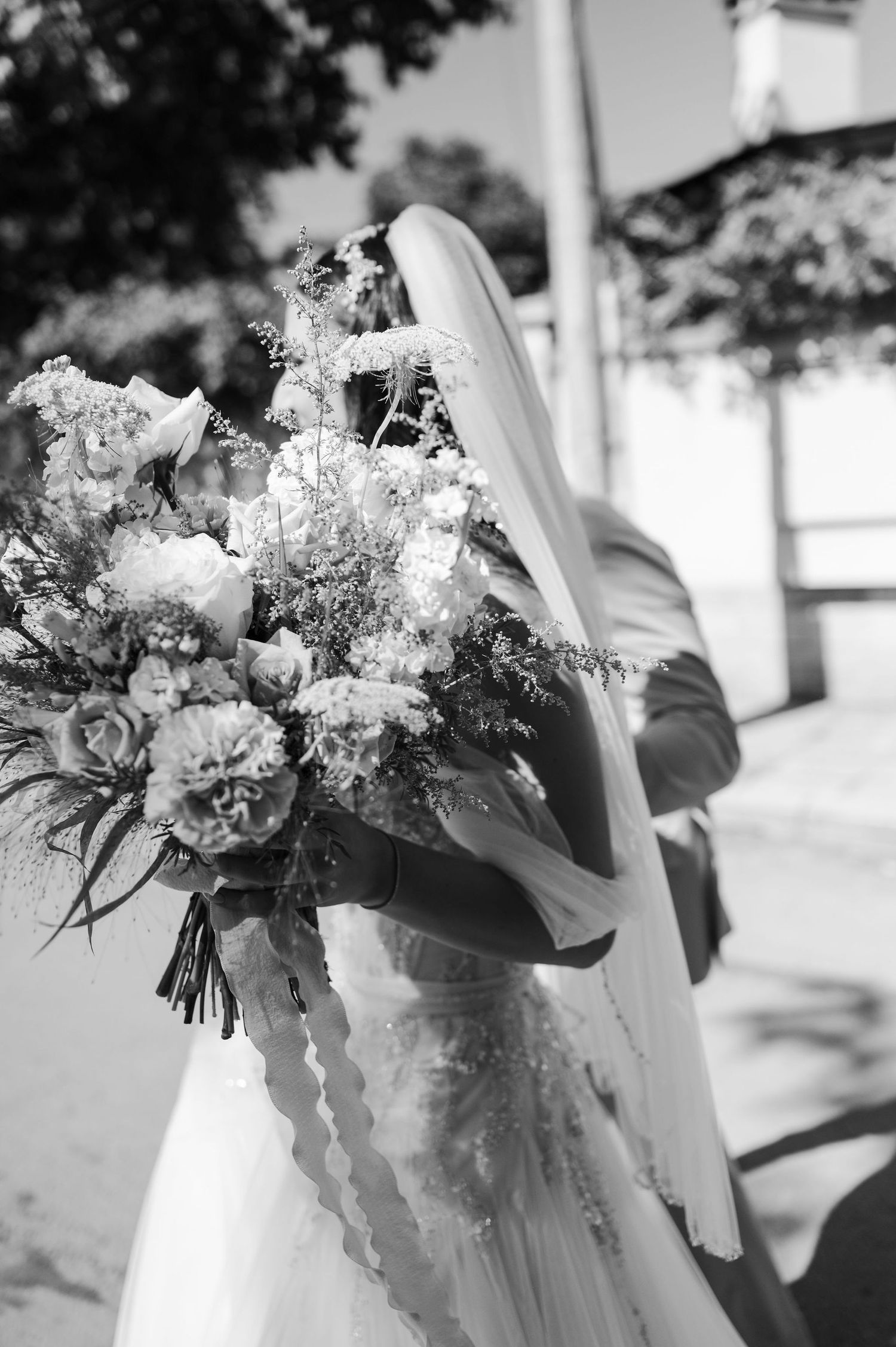 Black and white photo of elegant wedding bouquets with delicate flowers and ribbons.