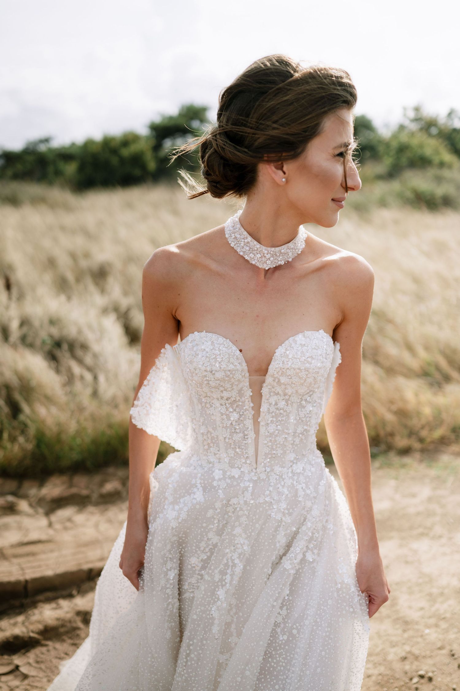 Close-up details of an intricate white wedding dress with beaded embellishments.