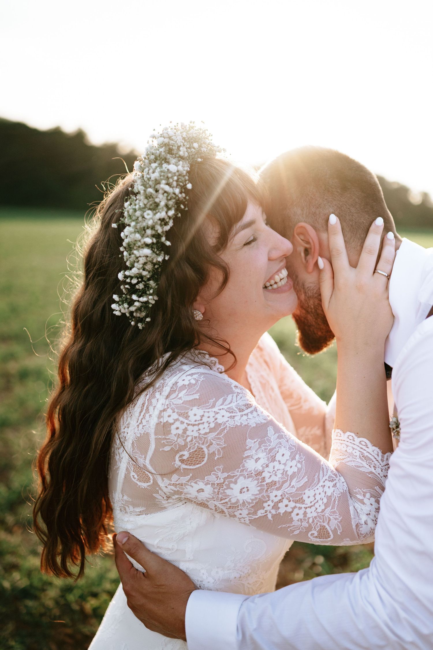 Romantic sunset wedding photos capture couple's tender embrace in outdoor setting.