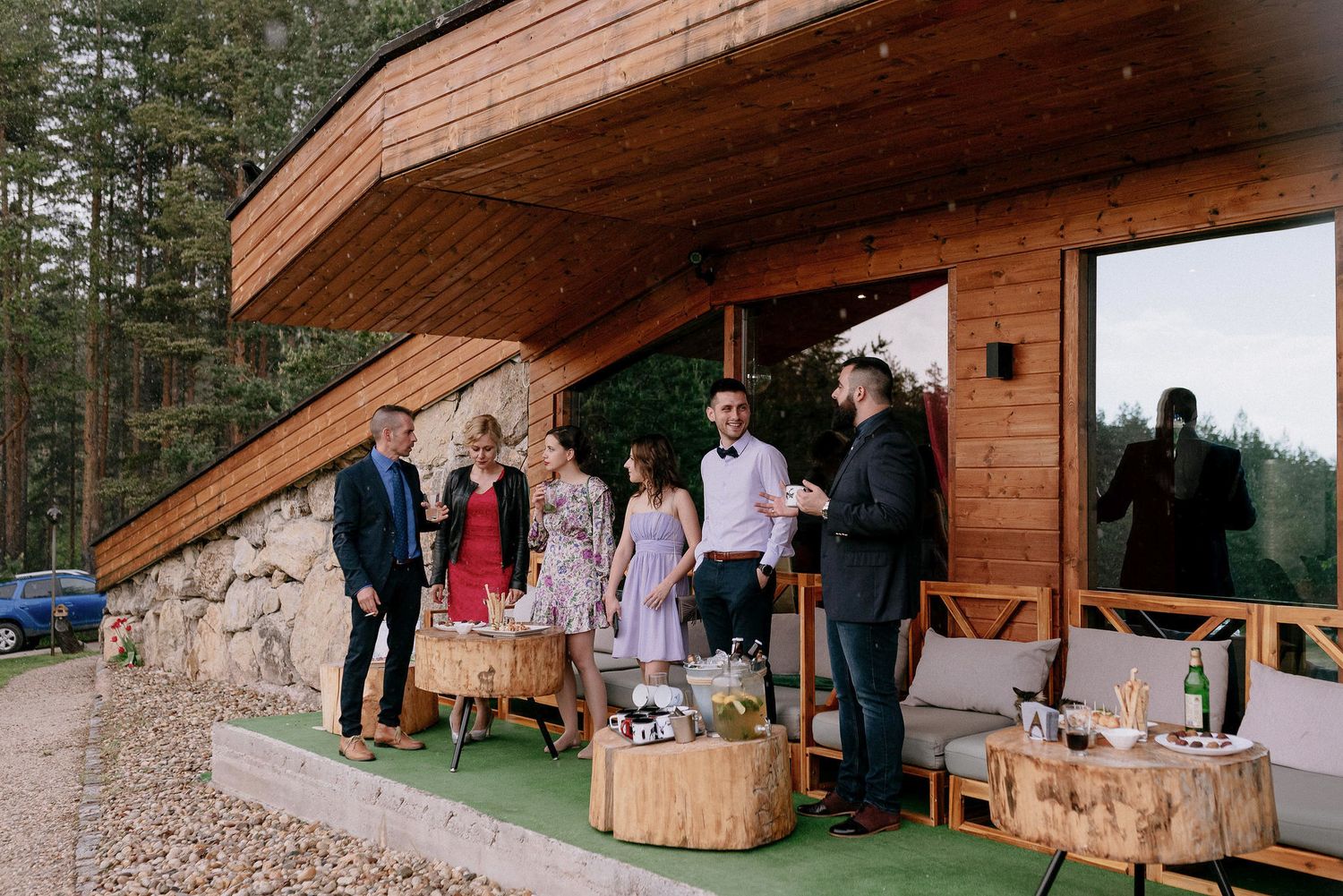 Wedding party gathered on a wooden deck with rustic wooden crates as decorative elements.