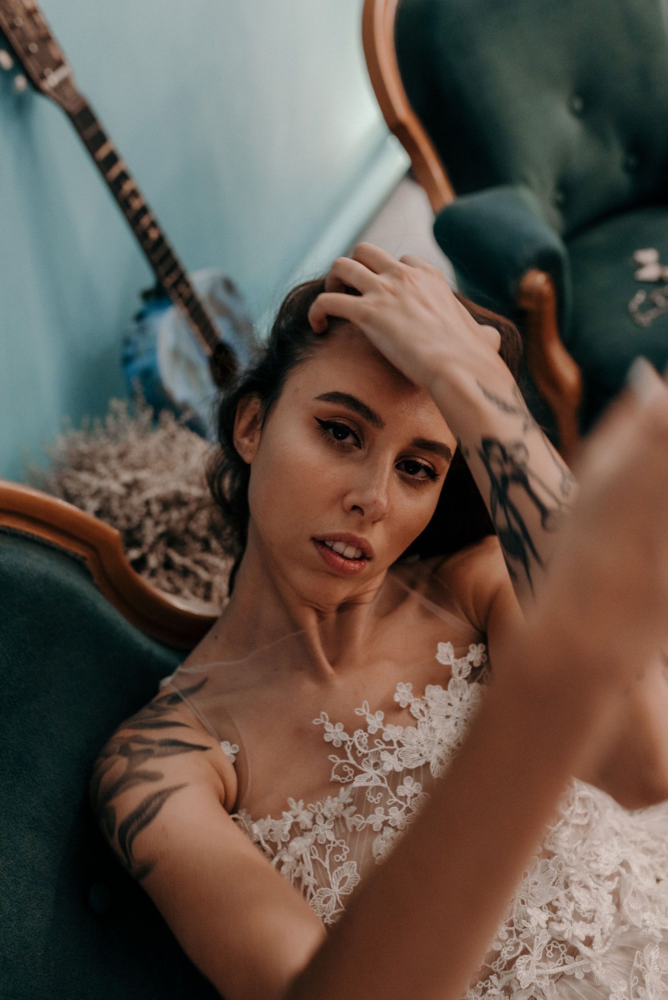 Artistic boudoir shot featuring lace wedding dress details and vintage decor.