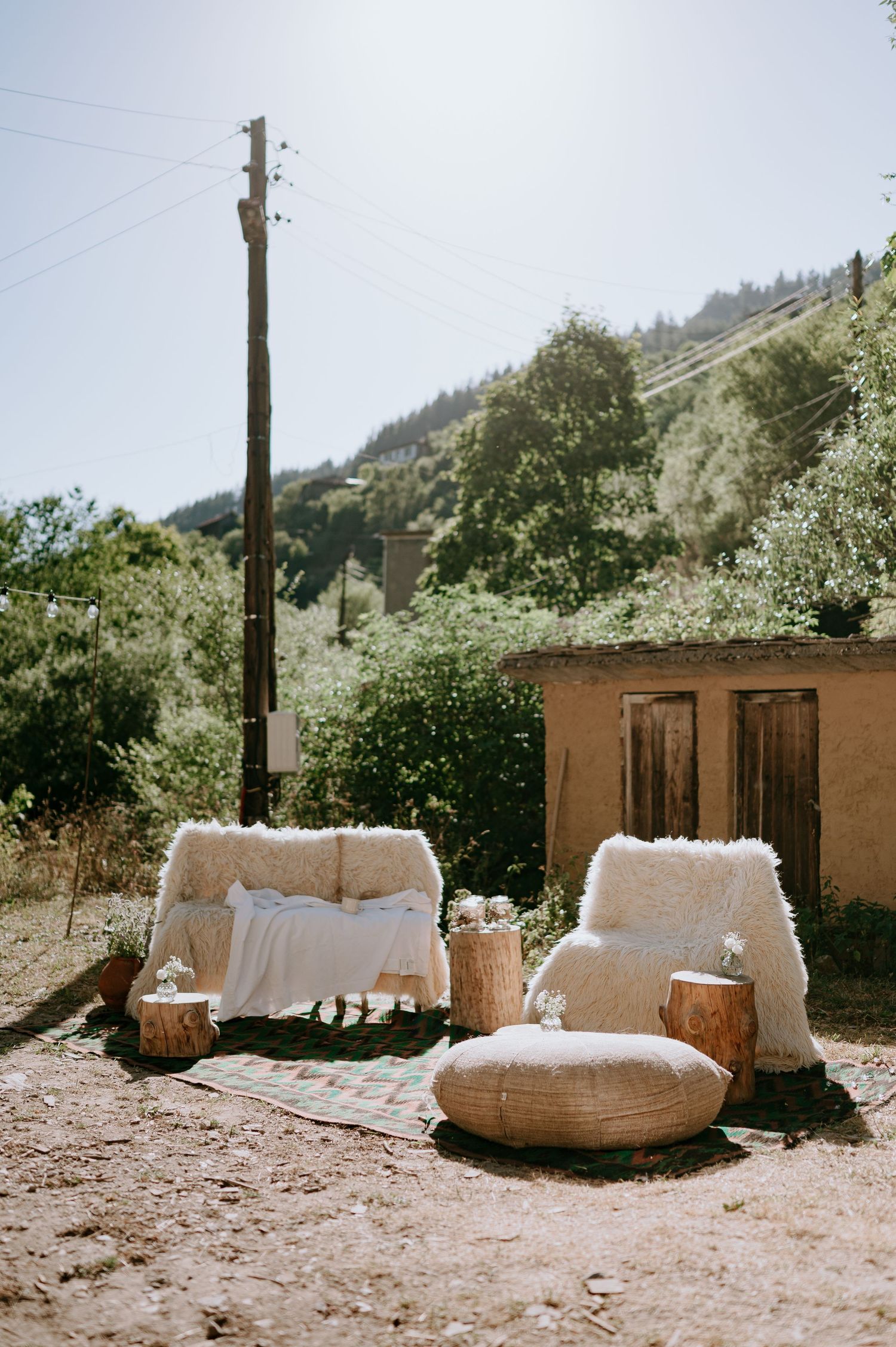 Rustic outdoor seating area with white cushioned benches against an adobe wall.