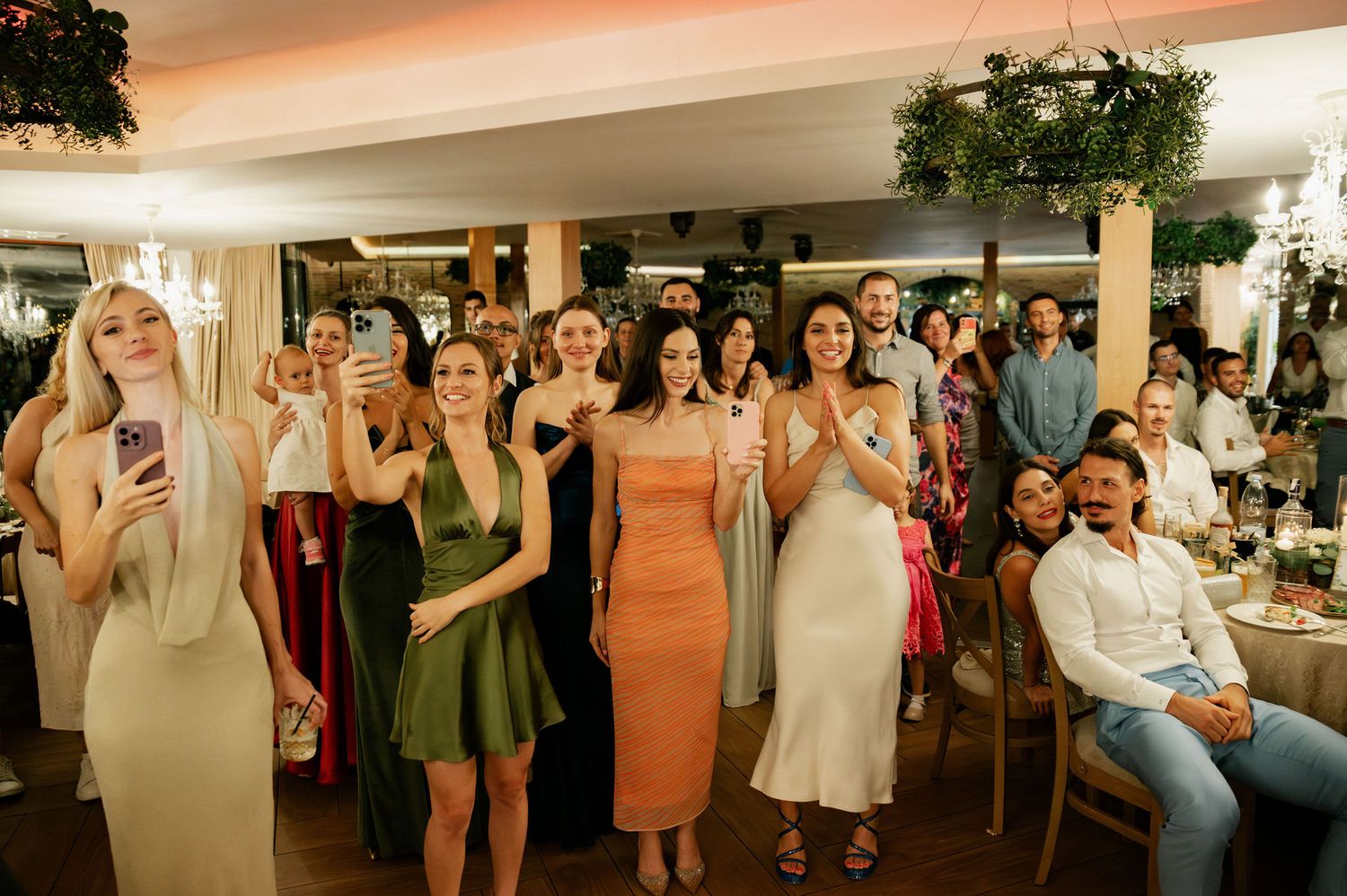 Wedding reception guests dancing and celebrating together on a dance floor in a decorated indoor venue.