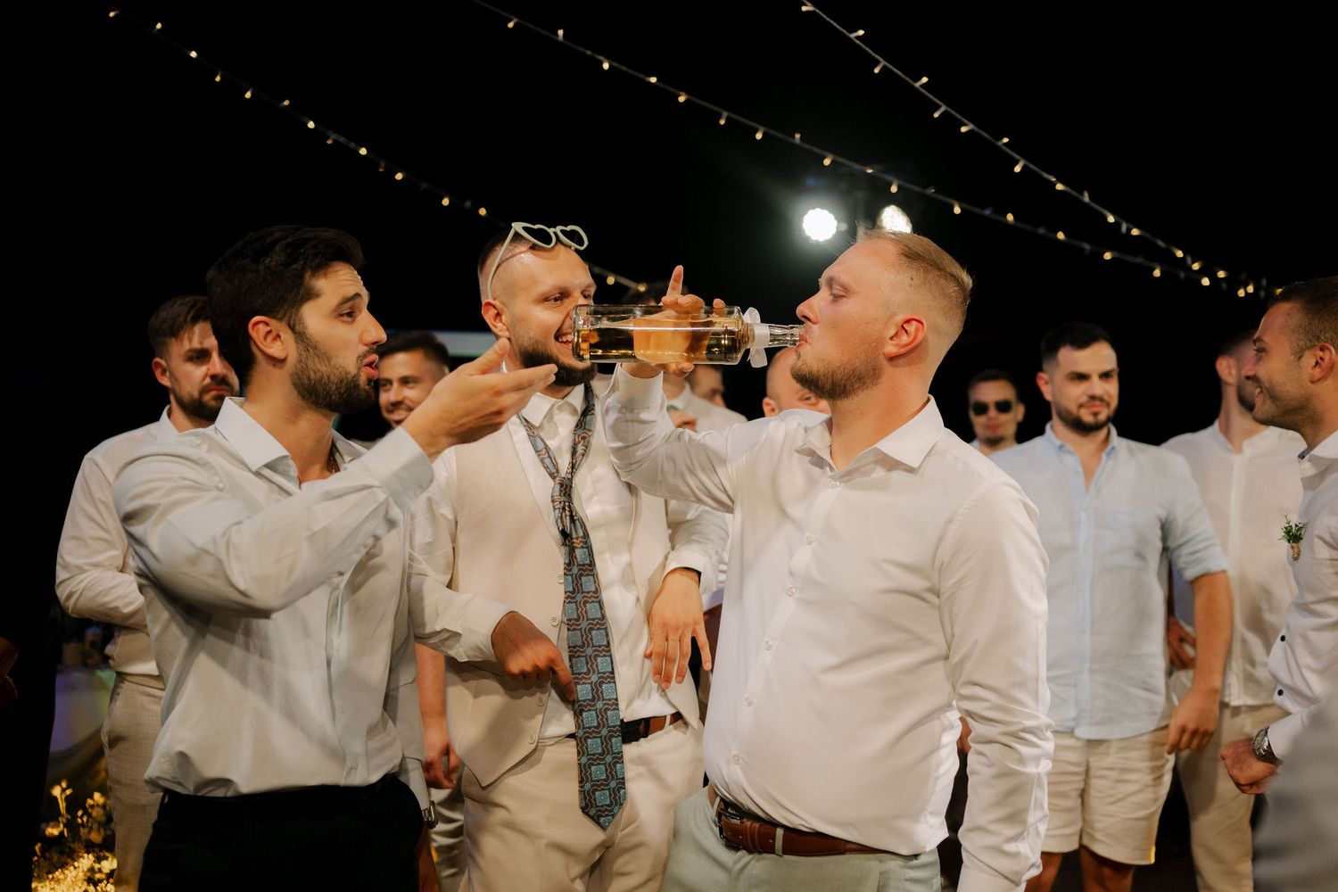 A series of black and white photos showing people dancing and celebrating at a wedding reception.