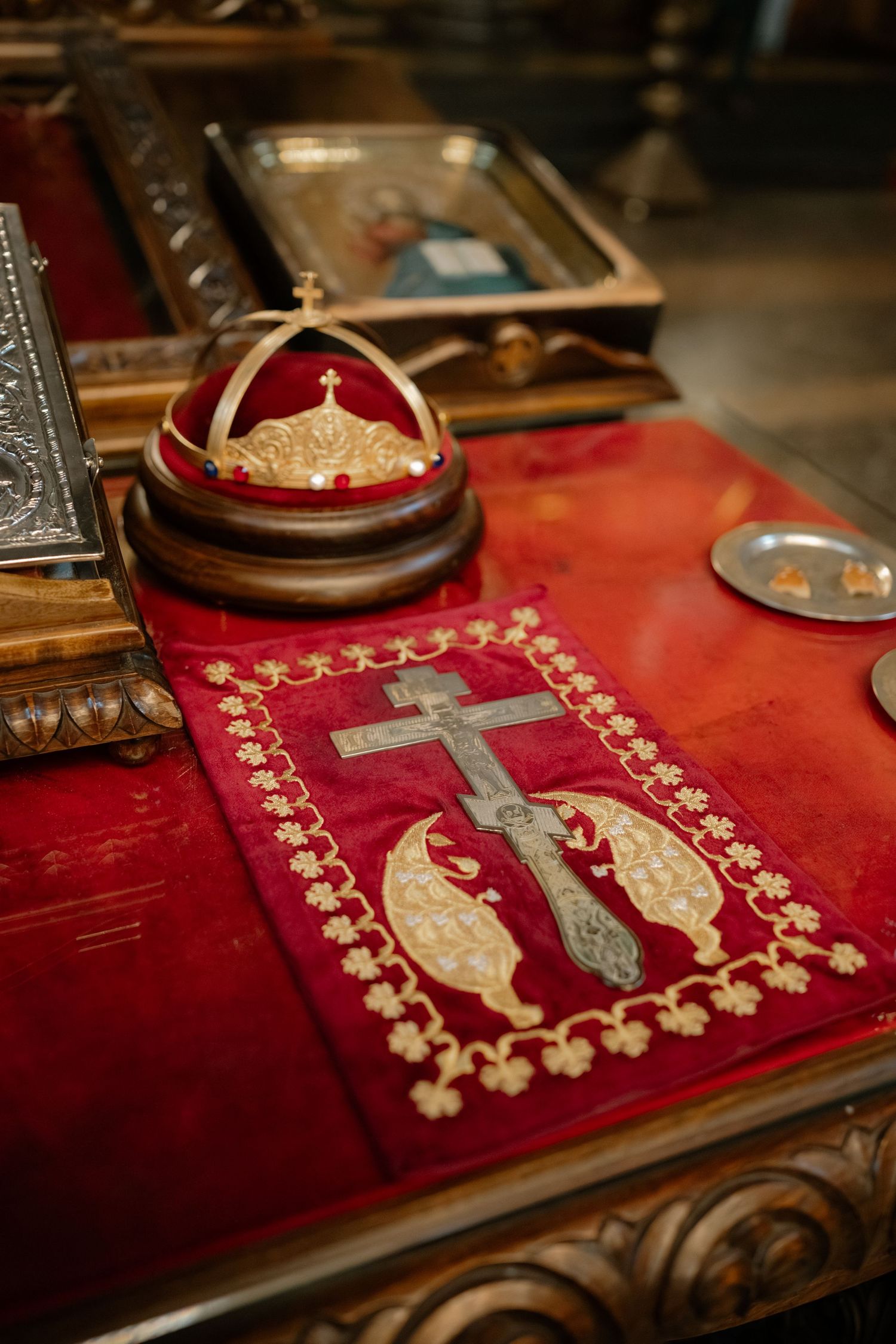 Orthodox religious items including an ornate red cloth with embroidered cross and a ceremonial crown on display.