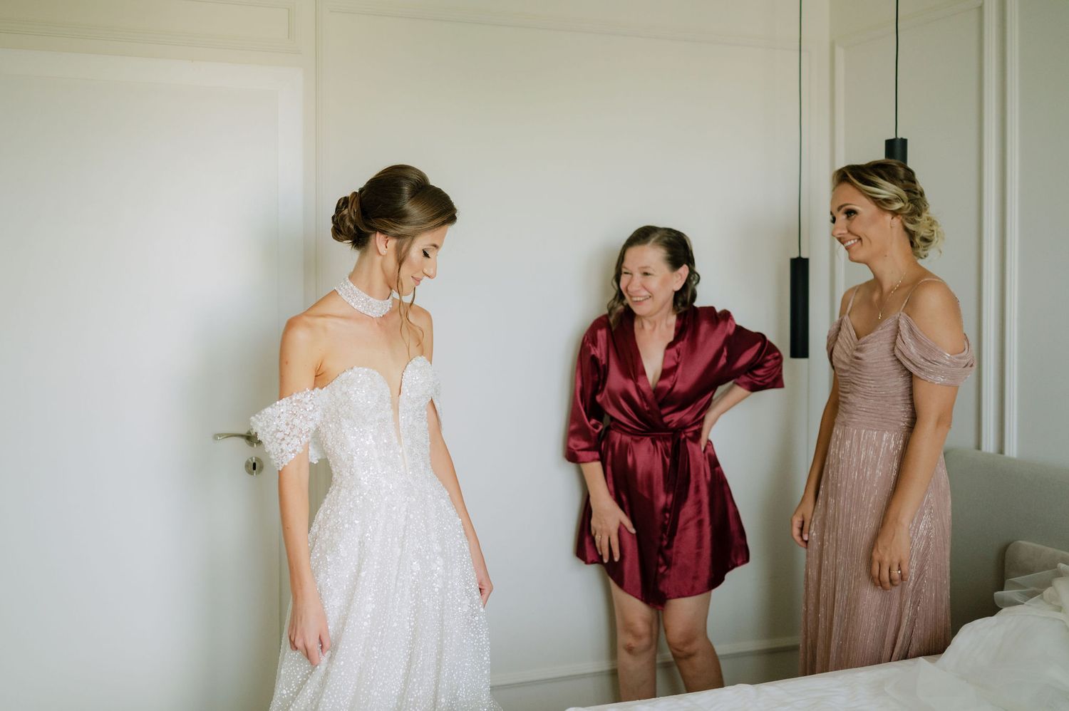 Wedding party members in burgundy and neutral tones prepare for the ceremony.