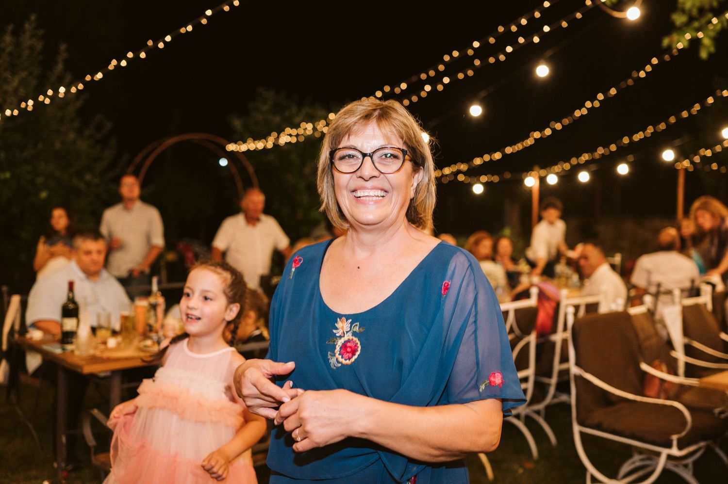 A guest enjoys the outdoor wedding reception under string lights.