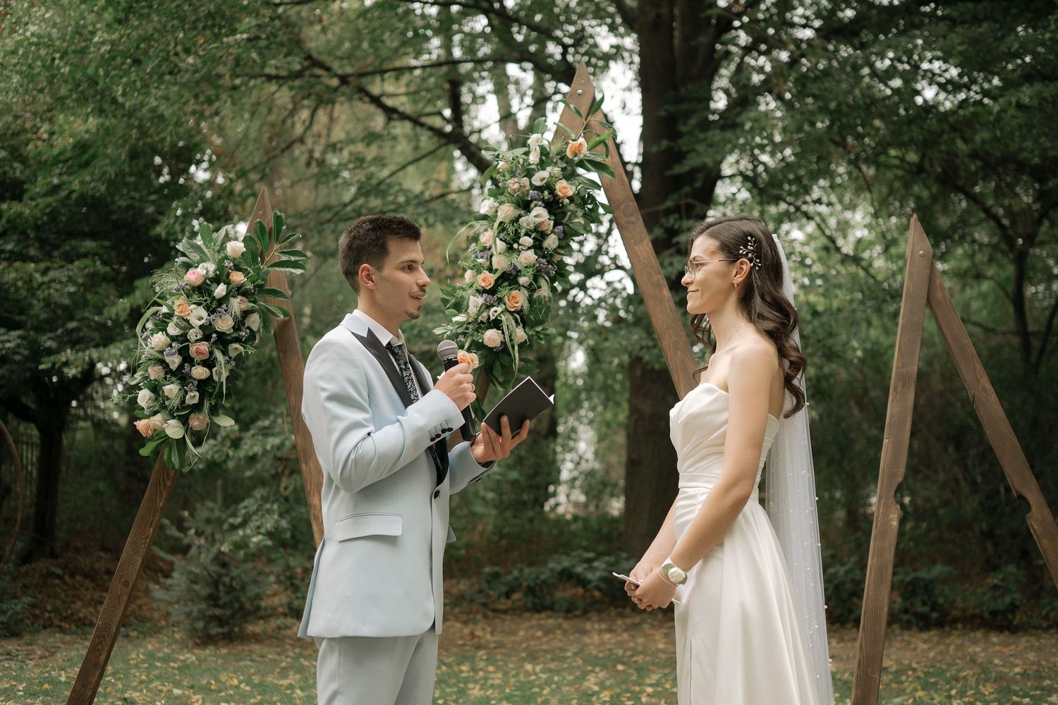 A couple shares a joyful dance moment together in a lush garden setting during their wedding celebration.