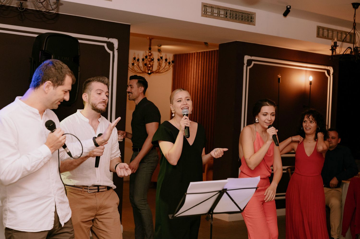 People dancing together in a social dance setting with warm lighting and wood paneled walls.