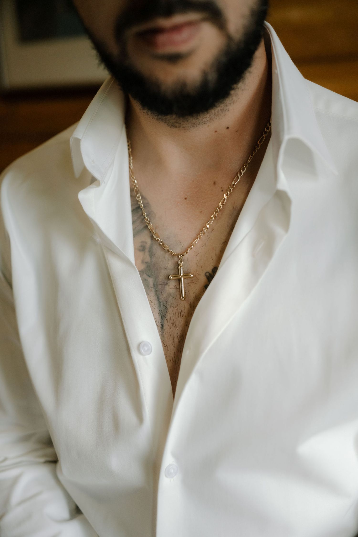 A person wearing a white button-down shirt and gold chain necklace with cross pendant shown in multiple cropped views.