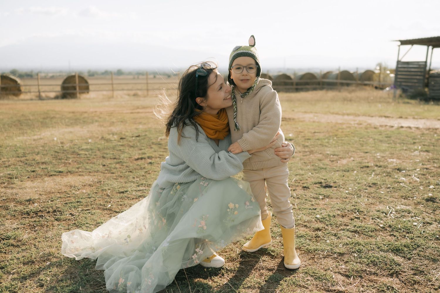 A couple in wedding attire shares tender moments together in a rustic outdoor setting during a photo session.