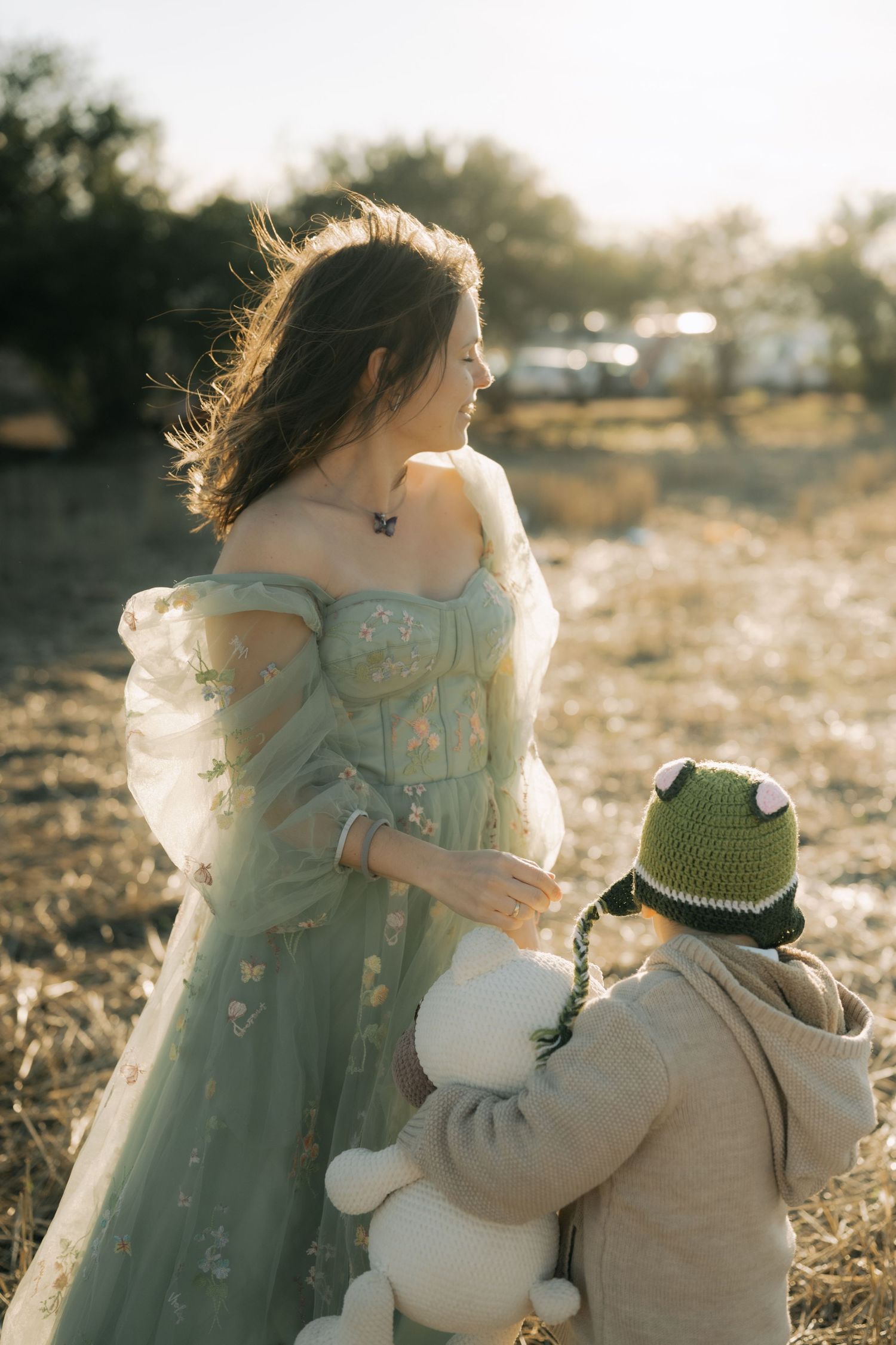 A romantic outdoor scene shows a flowing blue dress against a warm sunset backdrop with rustic charm.
