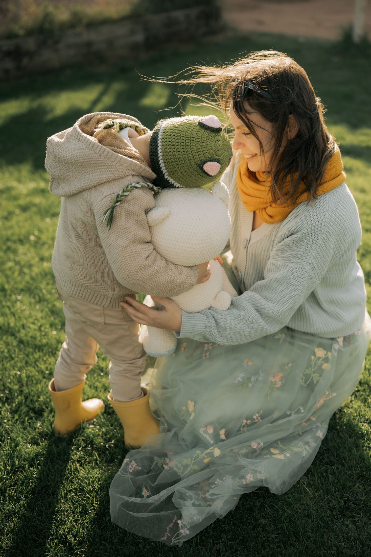 A series of intimate photos showing a person in a white sweater sitting on grass in warm sunlight.