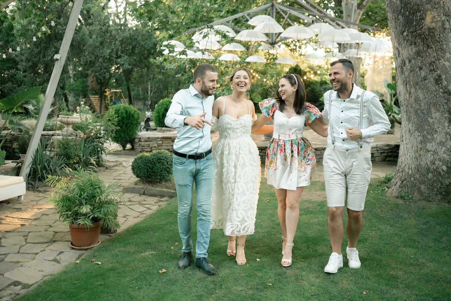 People stroll together through a lush garden path on a sunny summer afternoon.