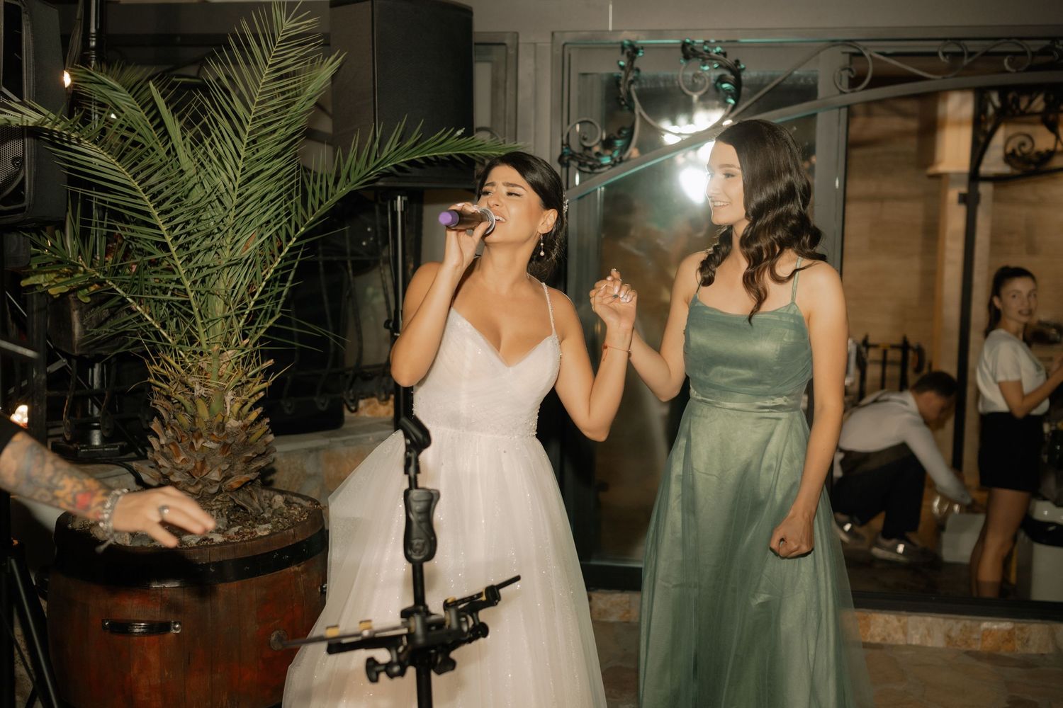 Wedding party guests dancing and celebrating on the dance floor at an evening reception.