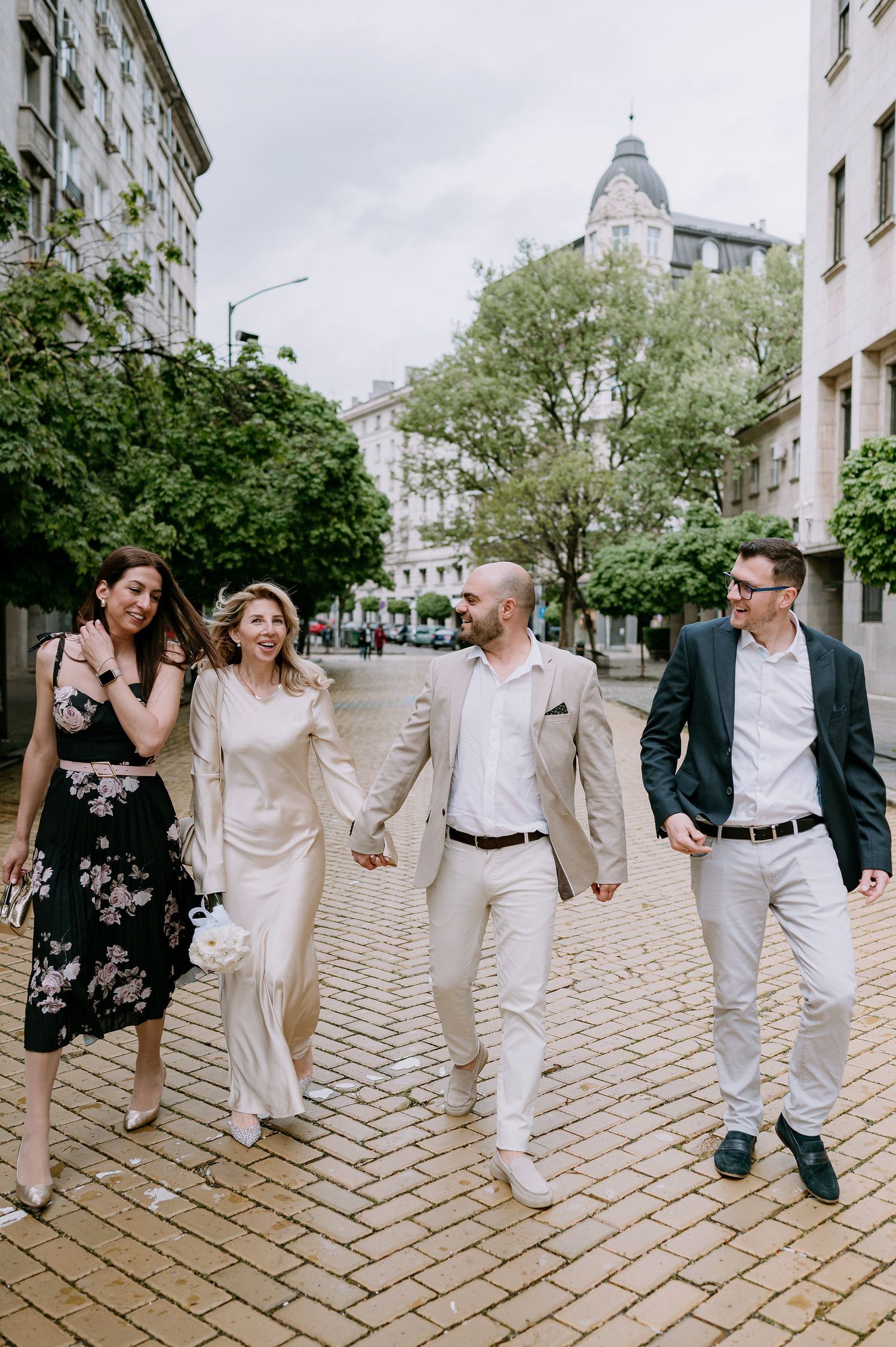 Group strolling together in coordinated outfits on a cobblestone pathway.