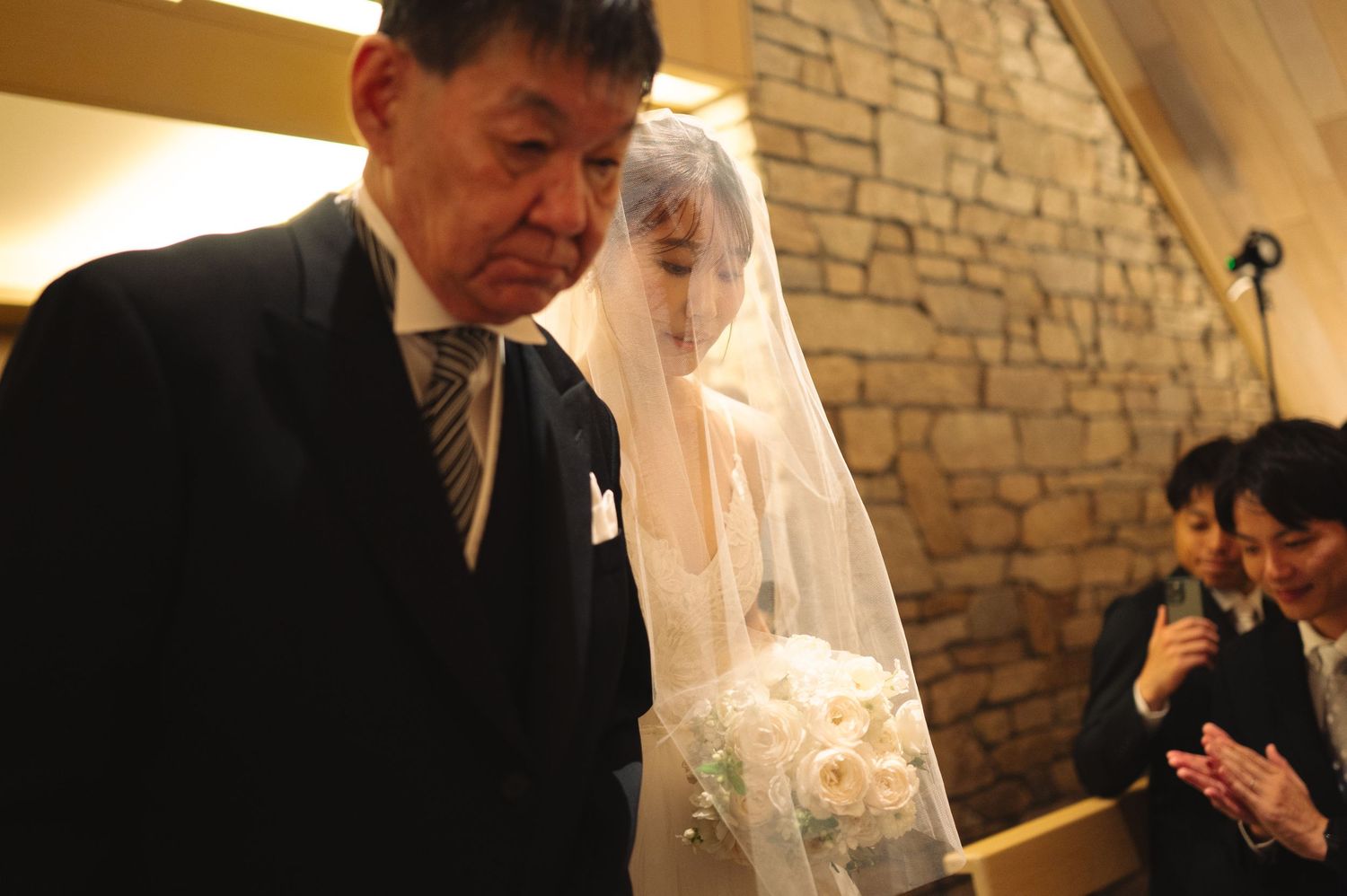 Modern chapel interior with stone walls during a wedding ceremony.