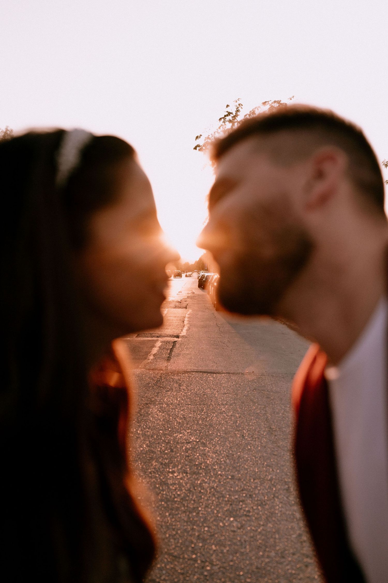 Romantic sunset silhouette on a street with warm golden lighting.