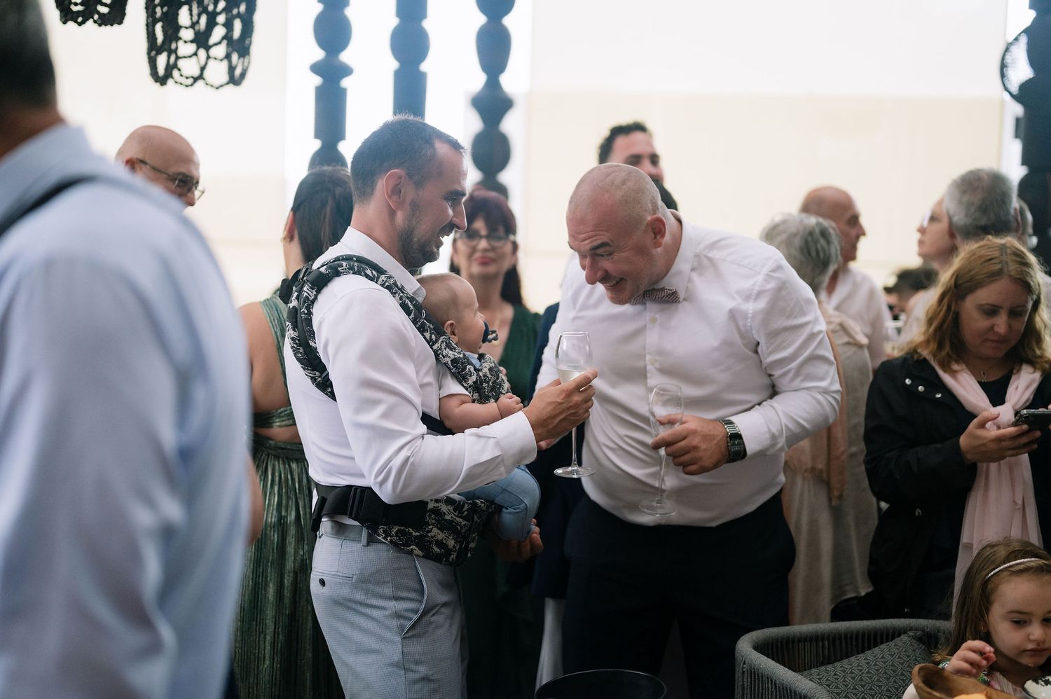 Wedding guests socialize during a reception in an elegant indoor venue.