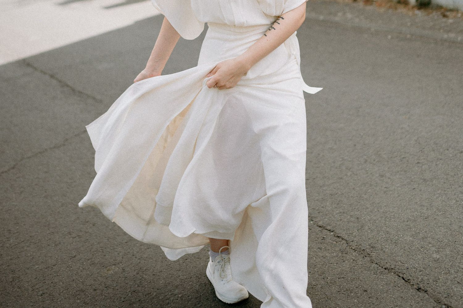 Flowing white dress movement captured on a street with dramatic lighting.