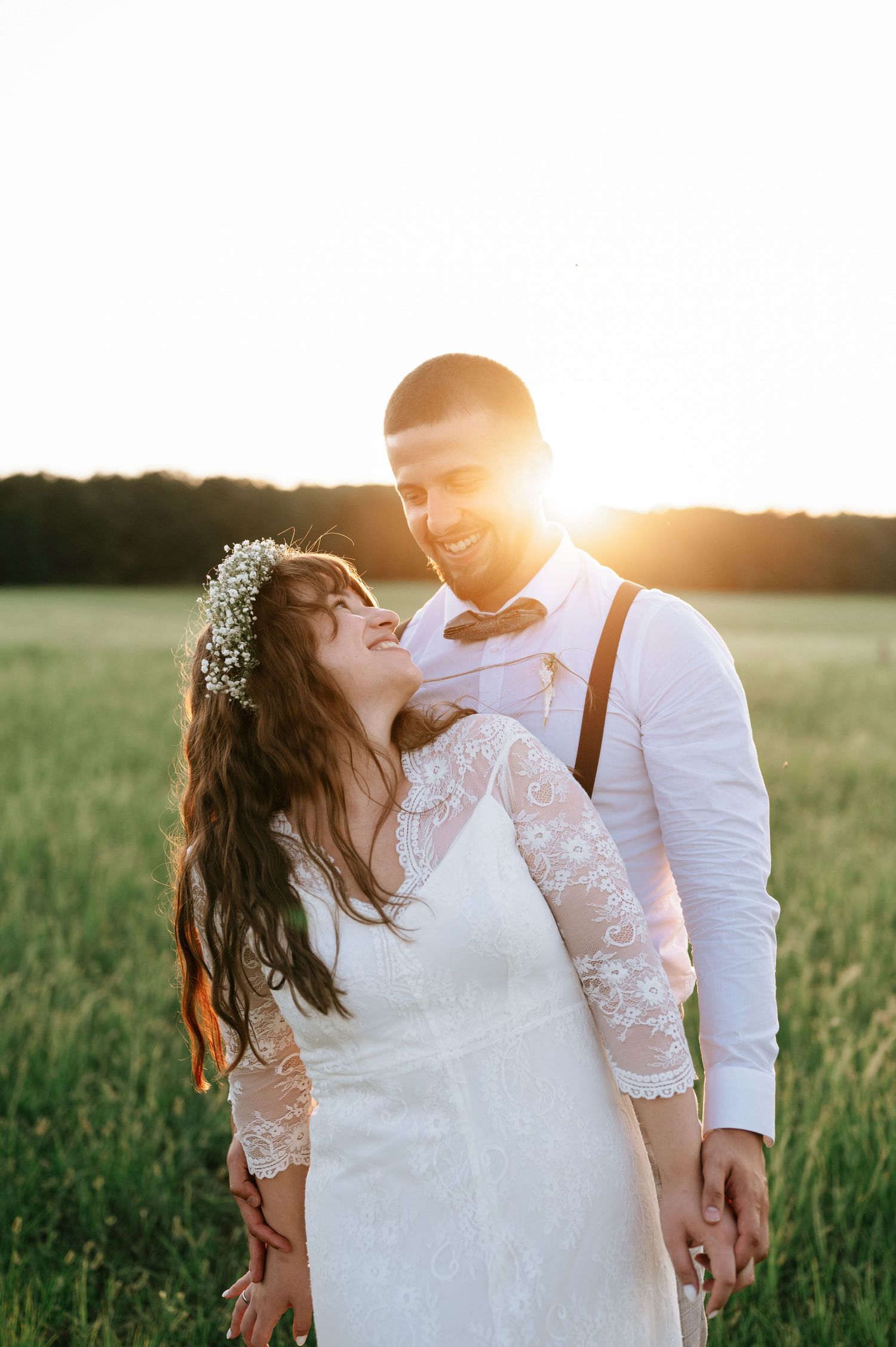 Intimate wedding portrait captured in a golden field at sunset.