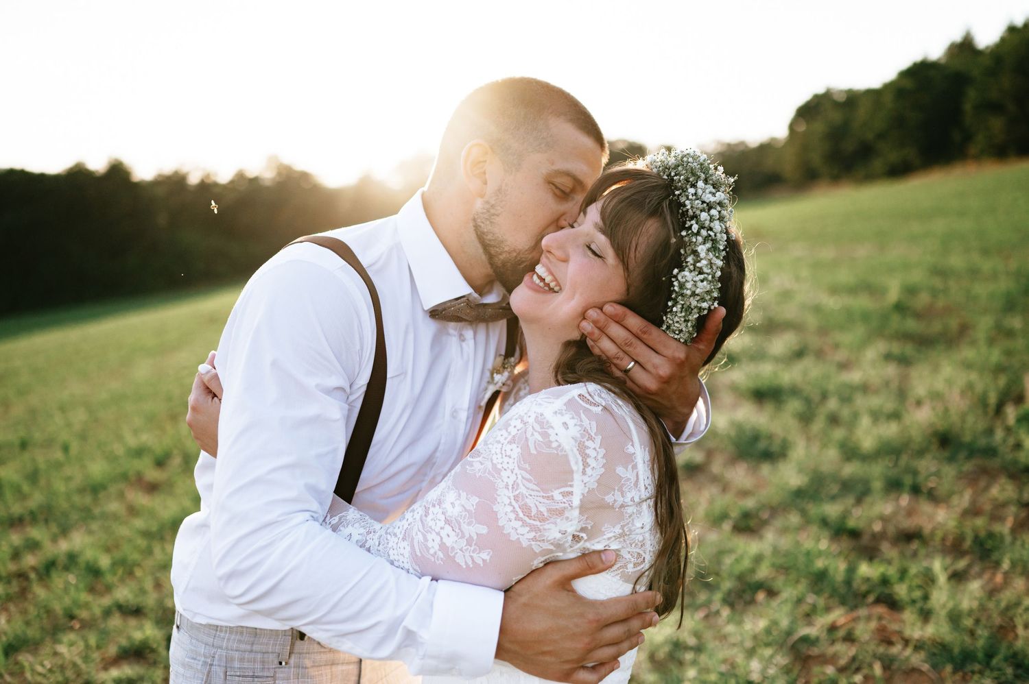 Close-up of romantic wedding couple moment in golden sunlight.