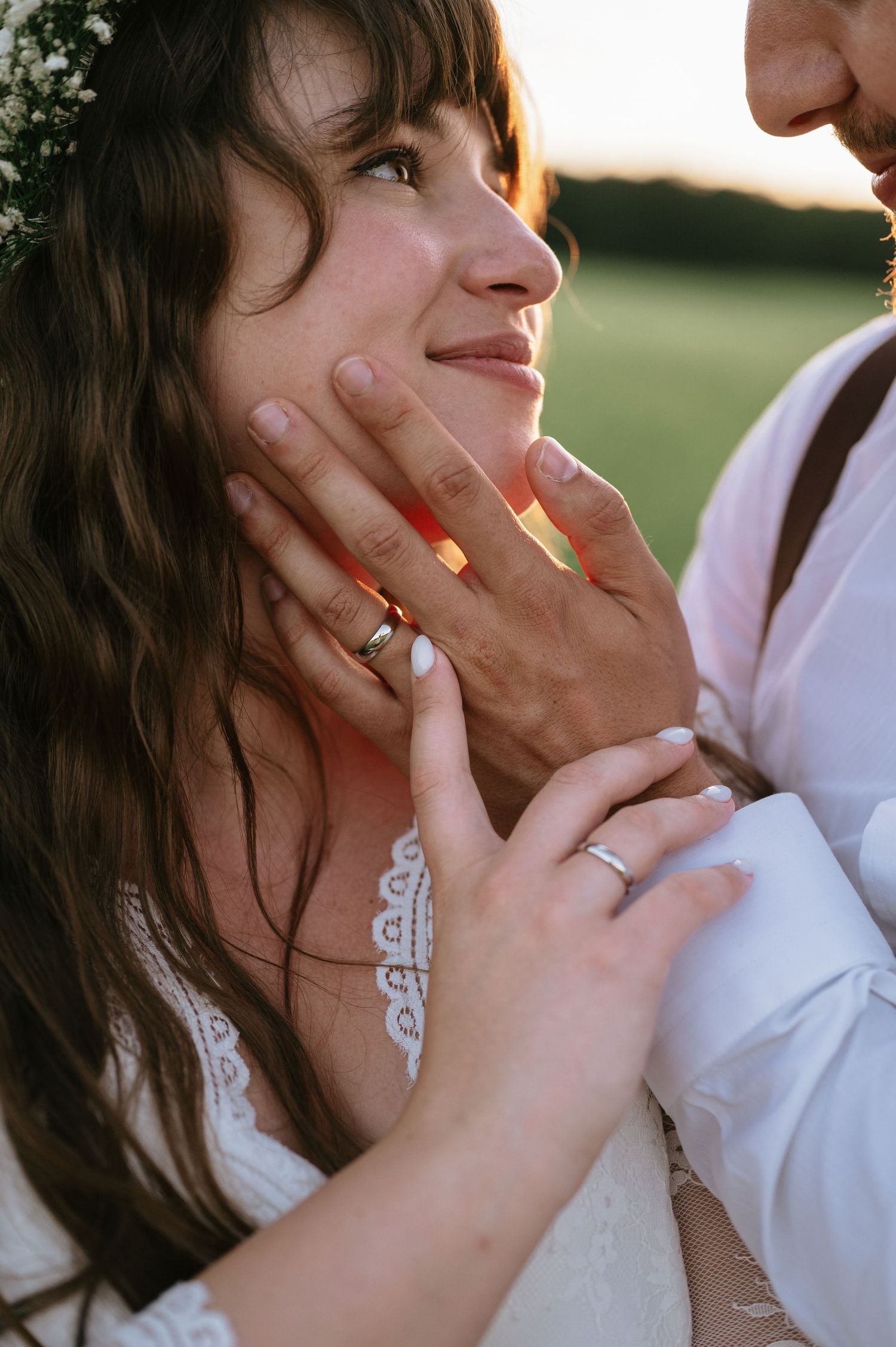 Intimate portrait of bride with baby's breath crown and lace dress during sunset.
