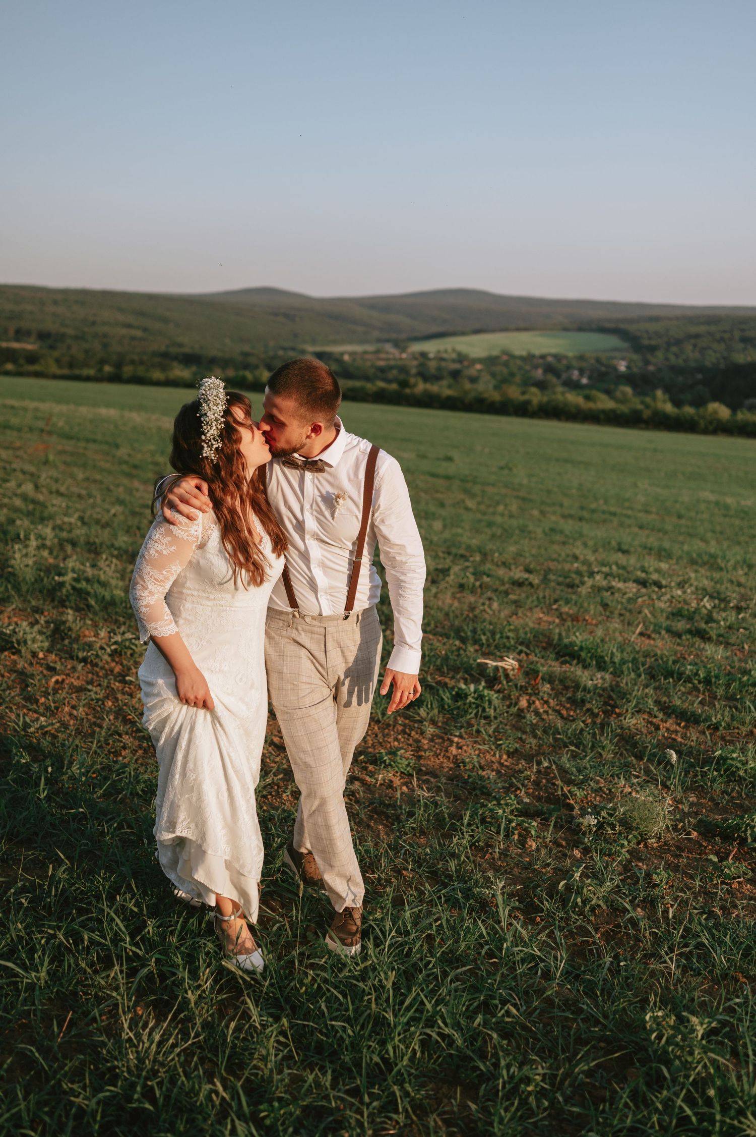 Intimate wedding portrait against rolling hills and countryside landscape at dusk.