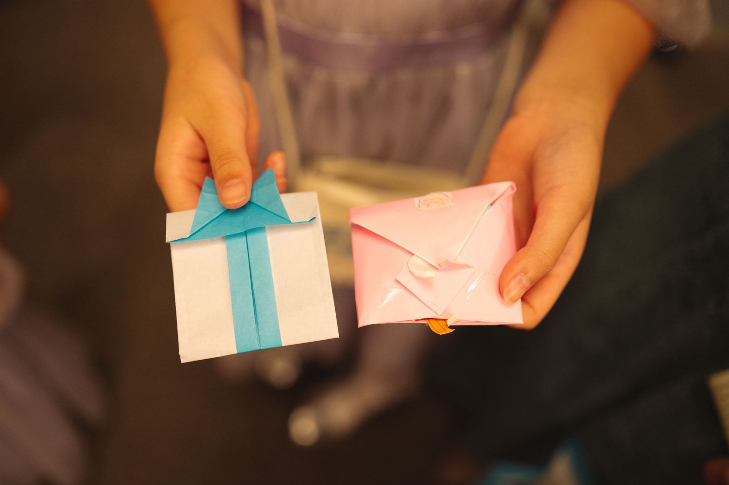 Close-up of hands holding small blue and white paper cards.
