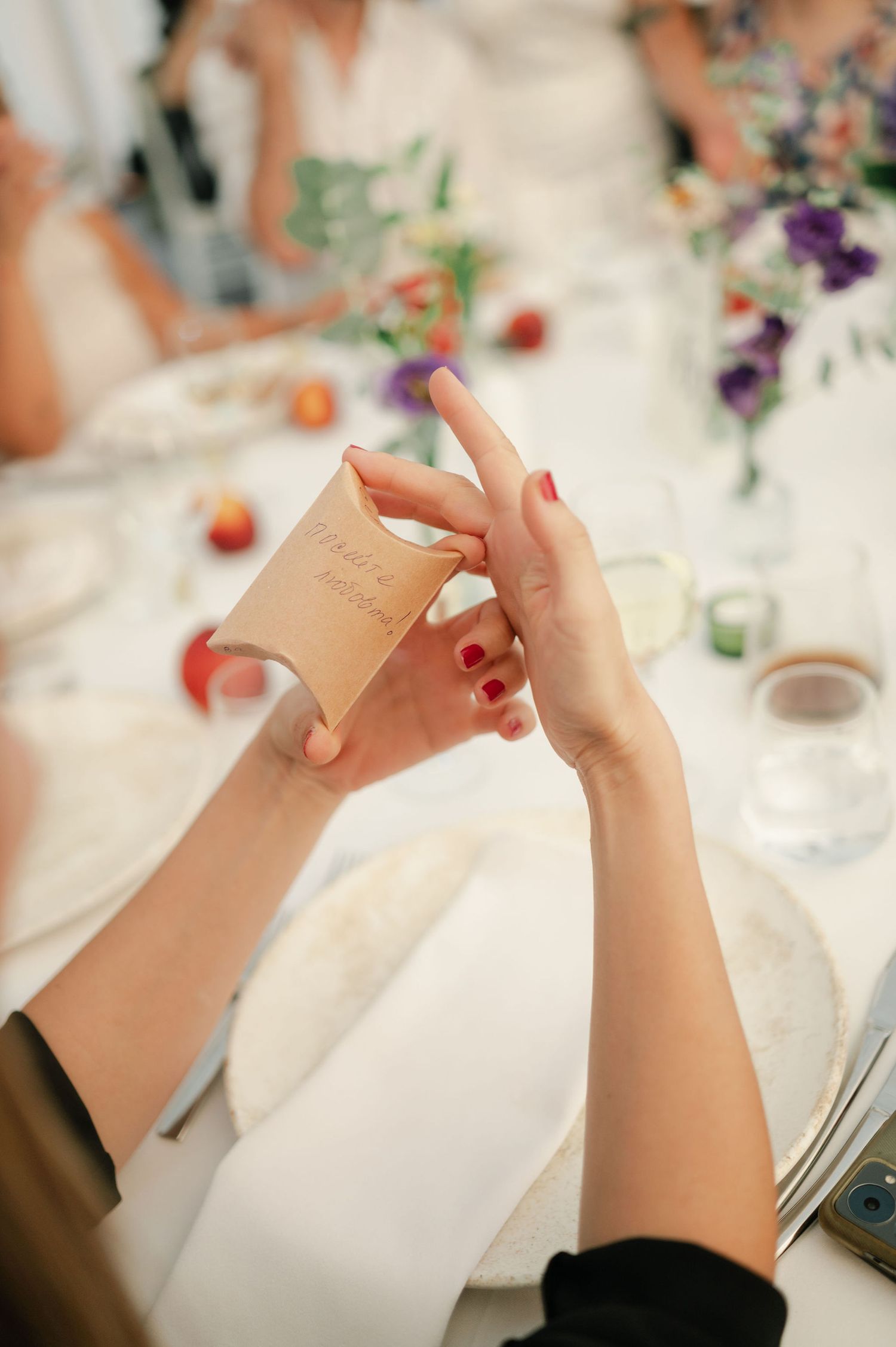 Close-up of hands holding napkins at an elegant wedding reception table.