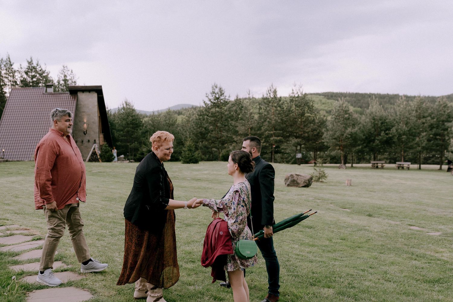 Wedding party enjoying outdoor festivities in a scenic mountain meadow.