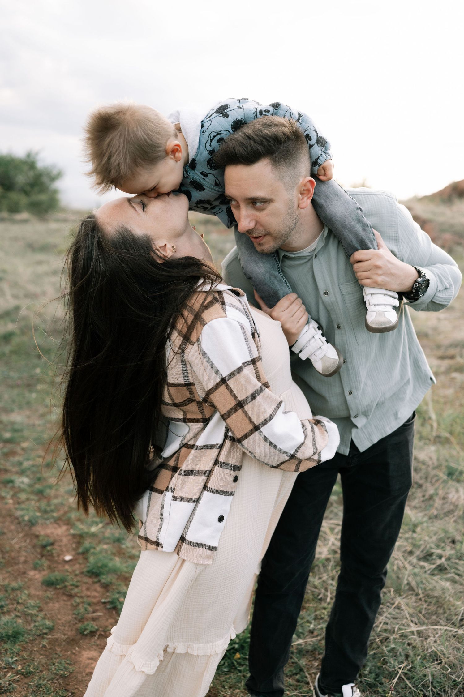 A romantic couple embraces outdoors while sharing a tender moment in a series of intimate poses.