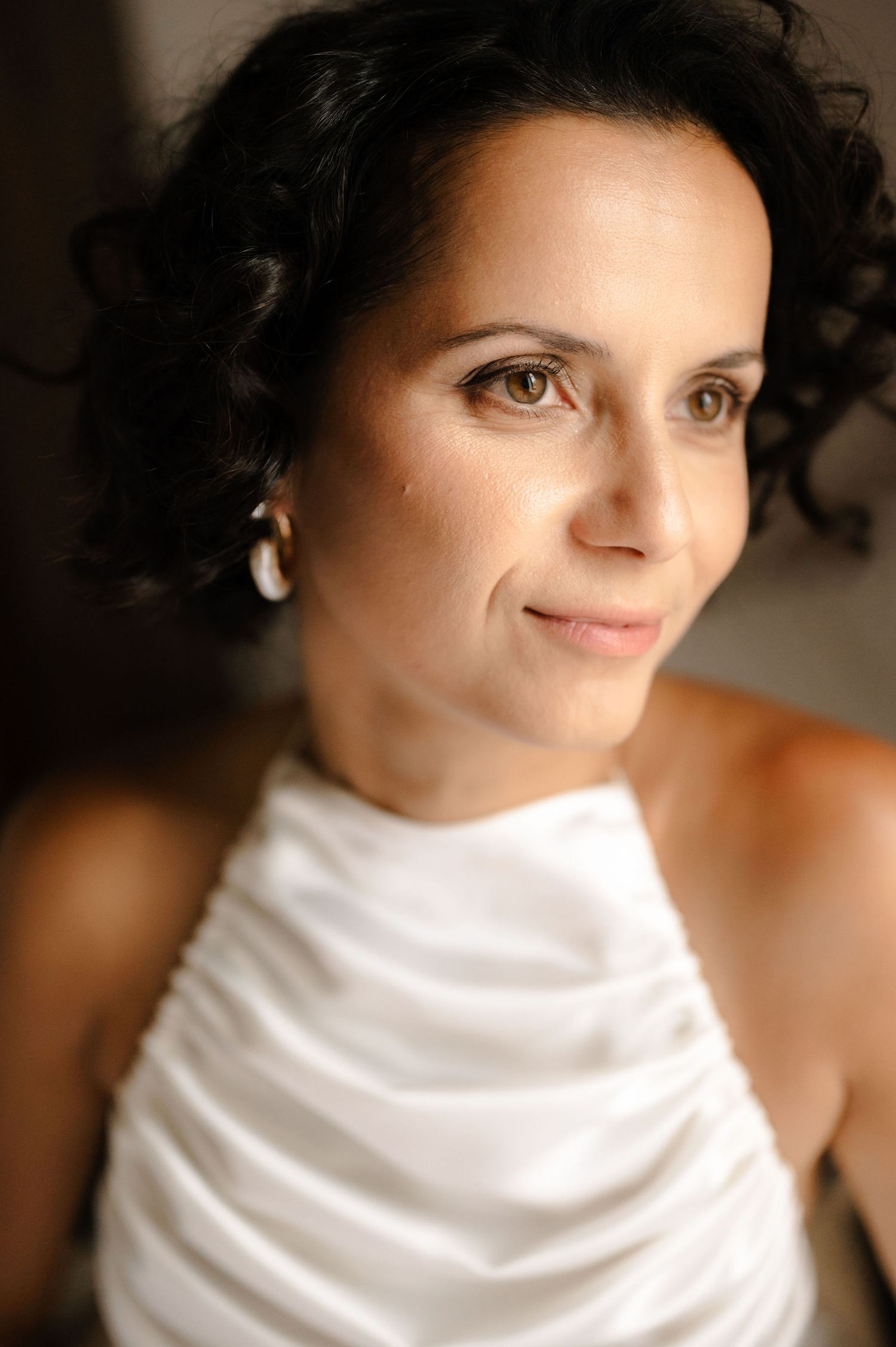 A series of photos showing a person wrapped in white fabric with soft lighting creating an artistic portrait effect.