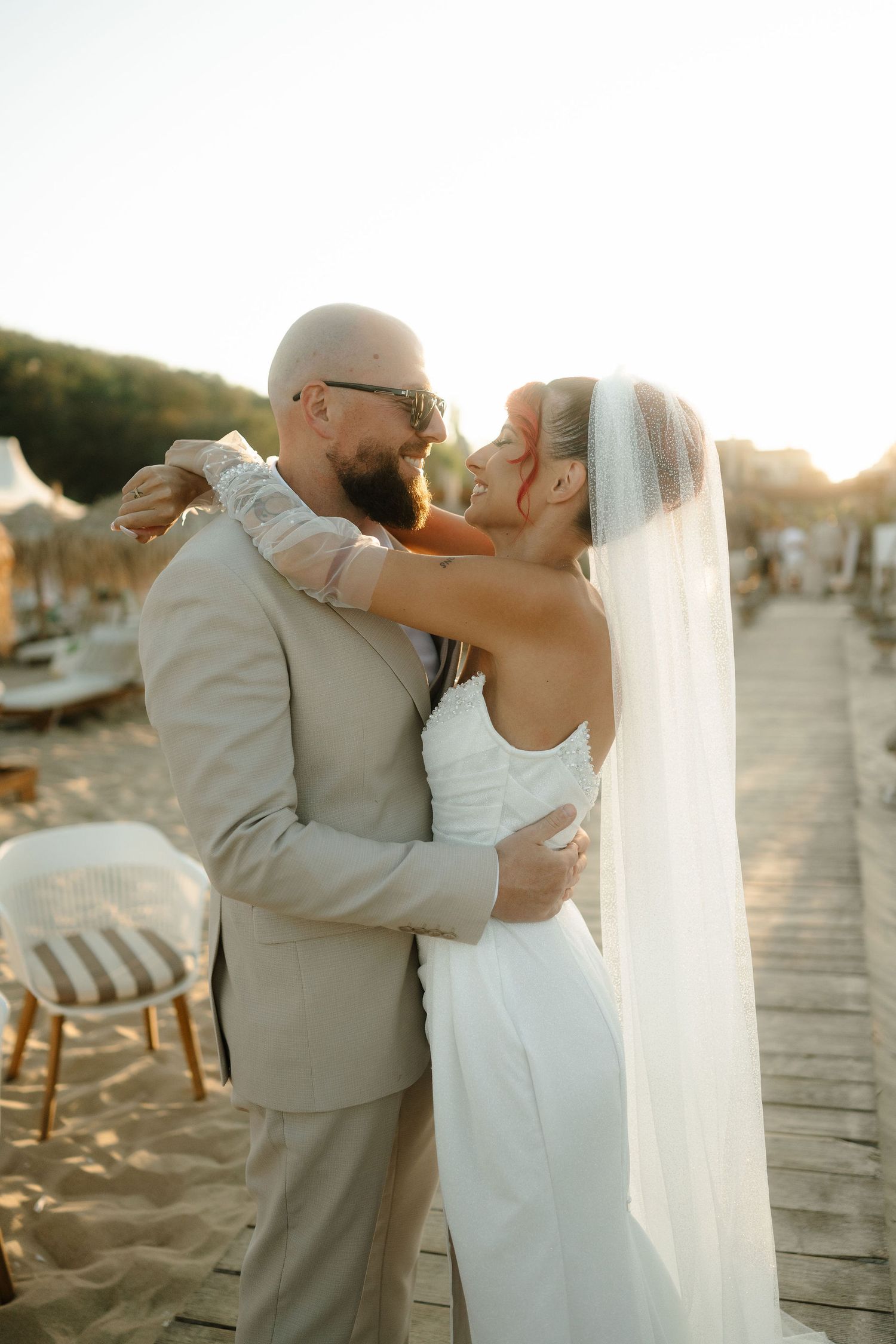 Romantic wedding couple sharing intimate kisses on a beach boardwalk at sunset in multiple candid shots.