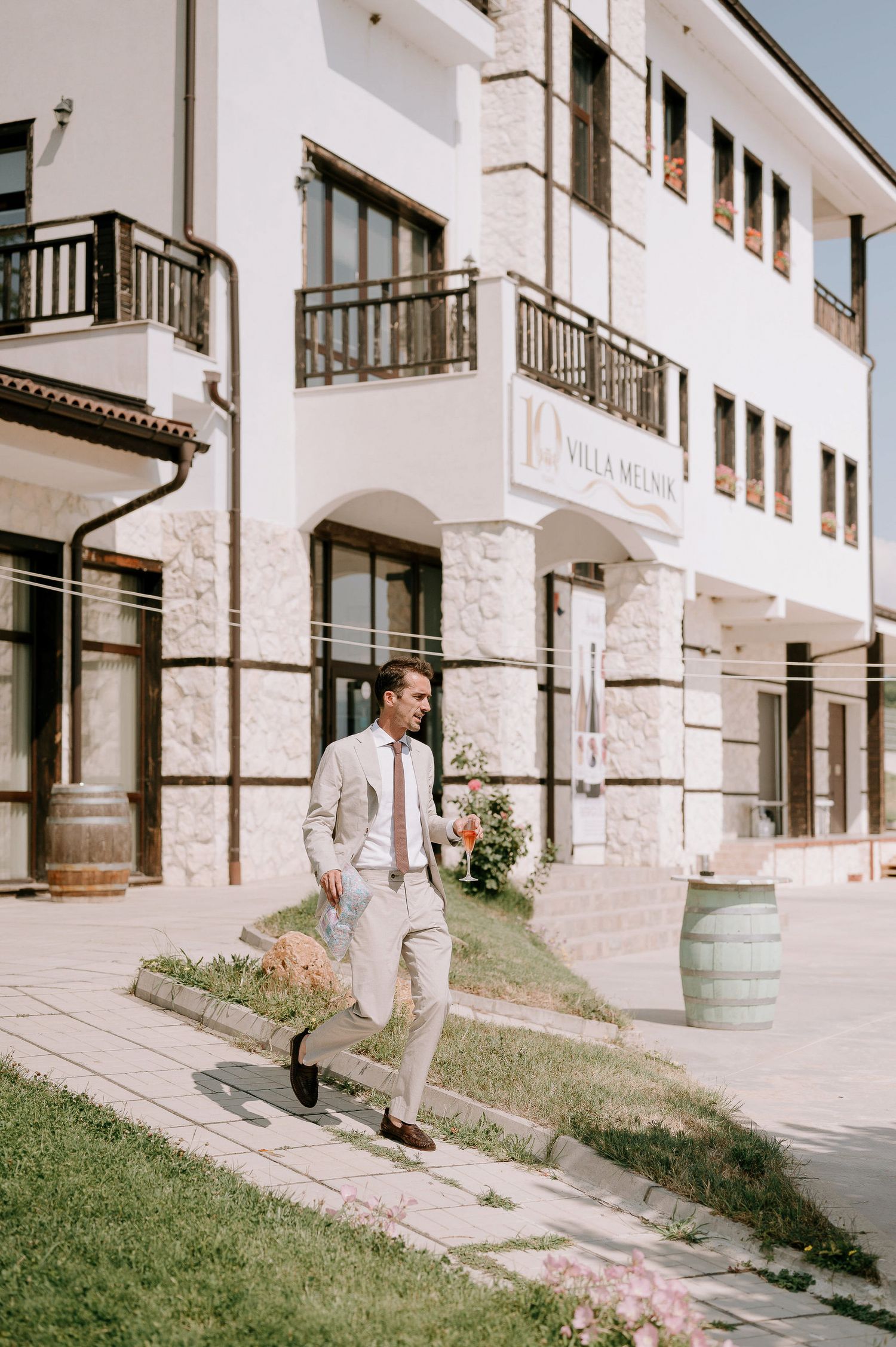 White Mediterranean-style building exterior with stone accents and wooden balconies.