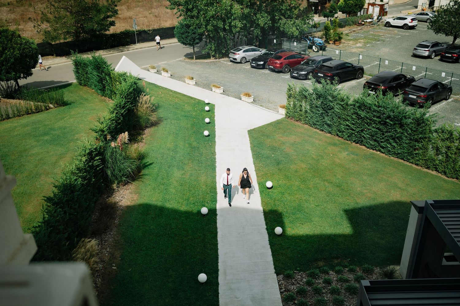 Aerial view of a parking lot and green landscaping with walking paths.