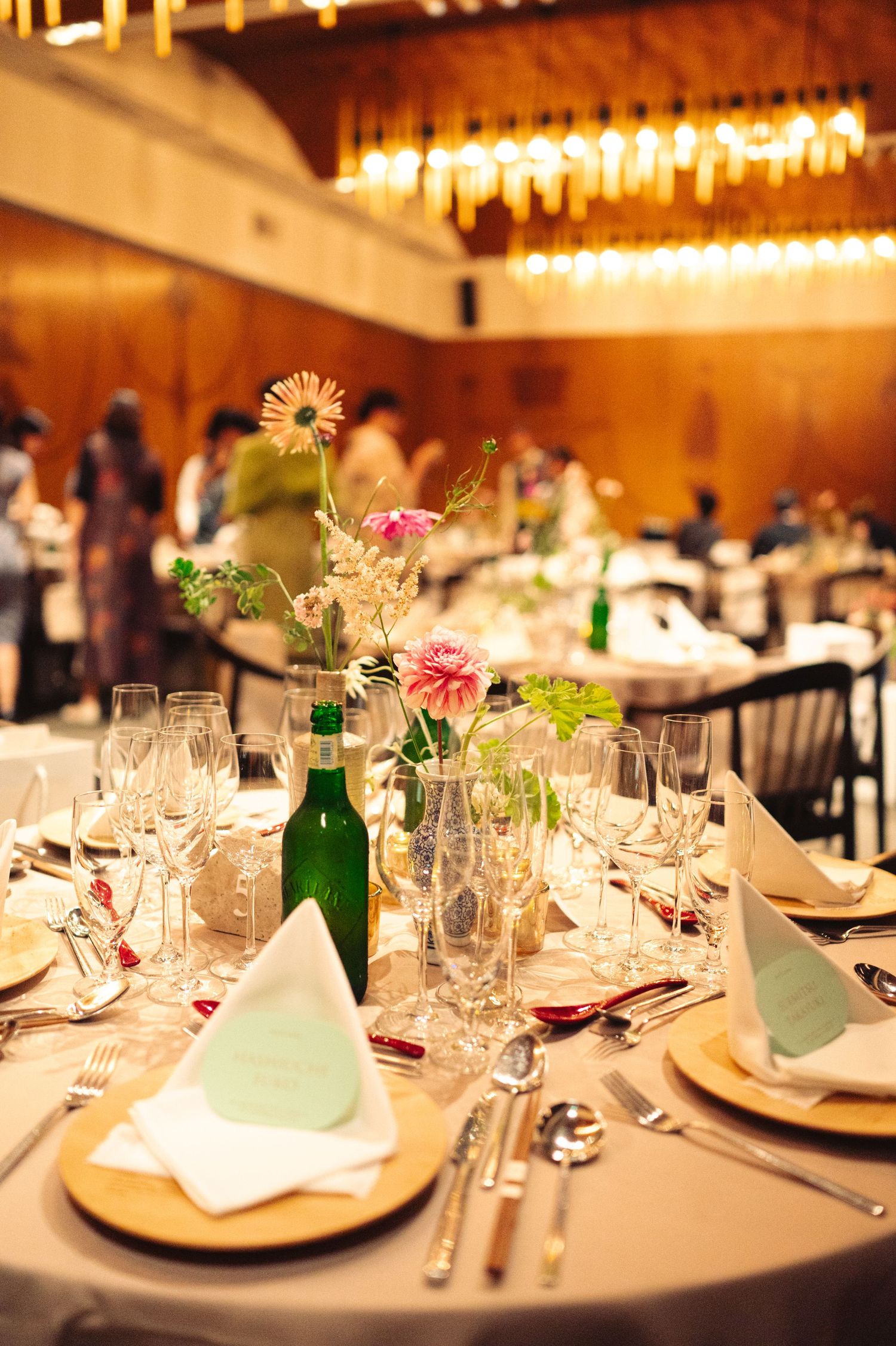 Elegant table settings with wine glasses, floral centerpieces and place cards at a formal dinner event.