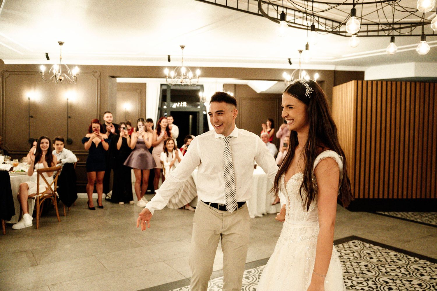 Wedding party dancing and celebrating on an elegant ballroom dance floor.