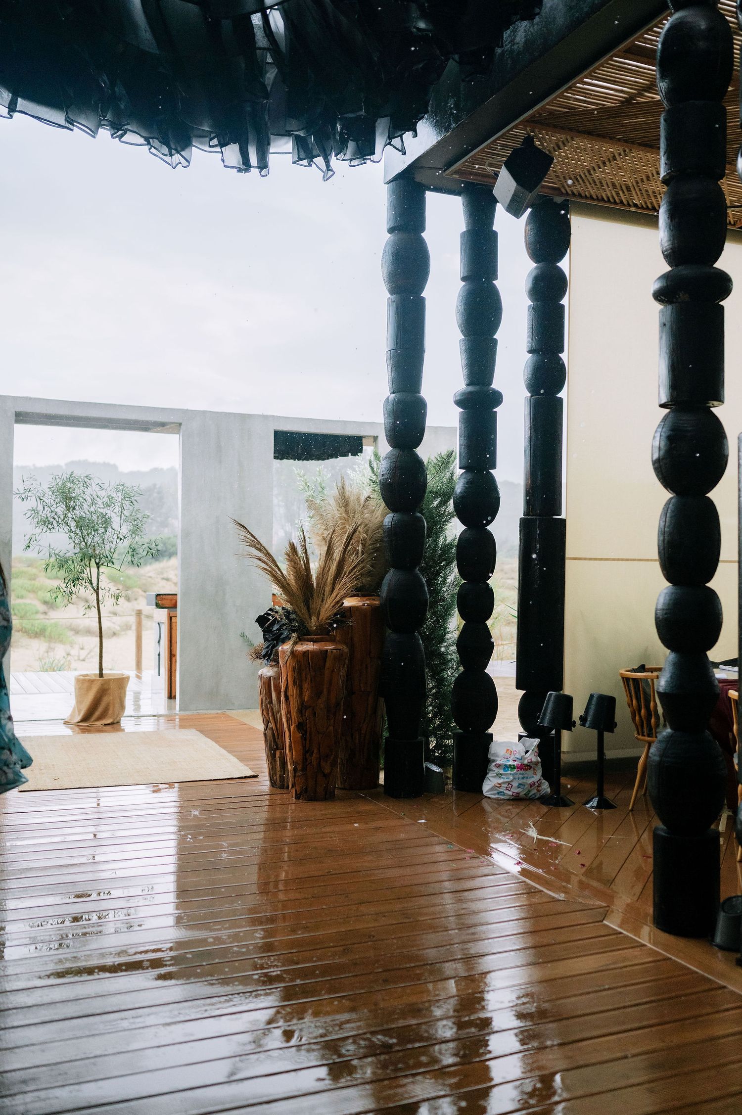 Empty wooden deck with ornate black pillars and natural lighting.