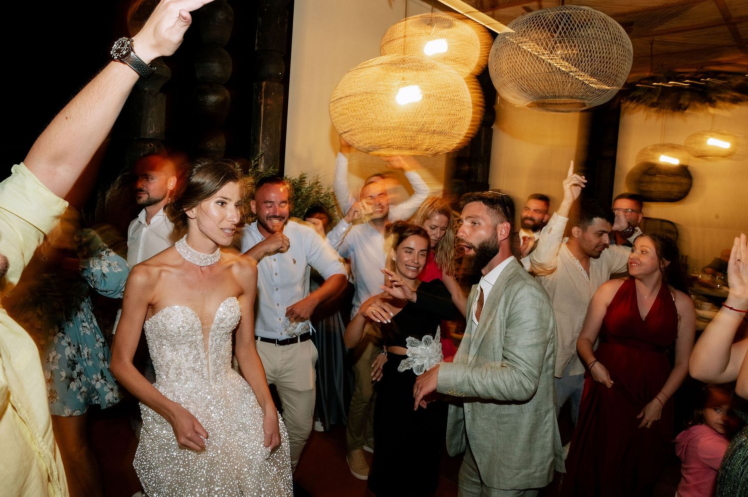 Crowded dance floor filled with people celebrating and dancing at an indoor event.