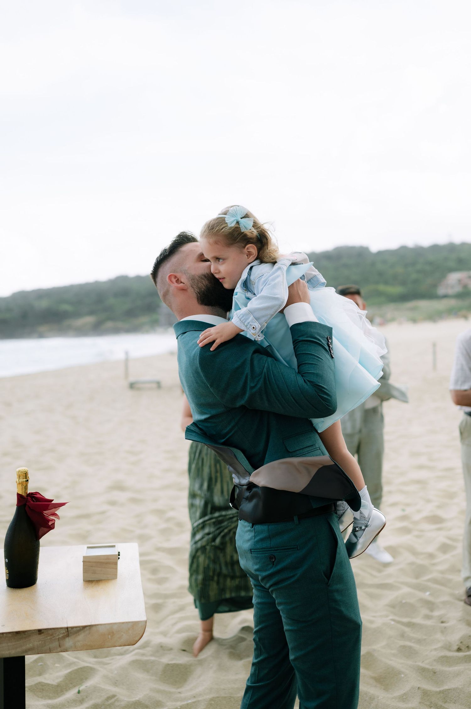 Emotional embrace between people during beach wedding celebration.