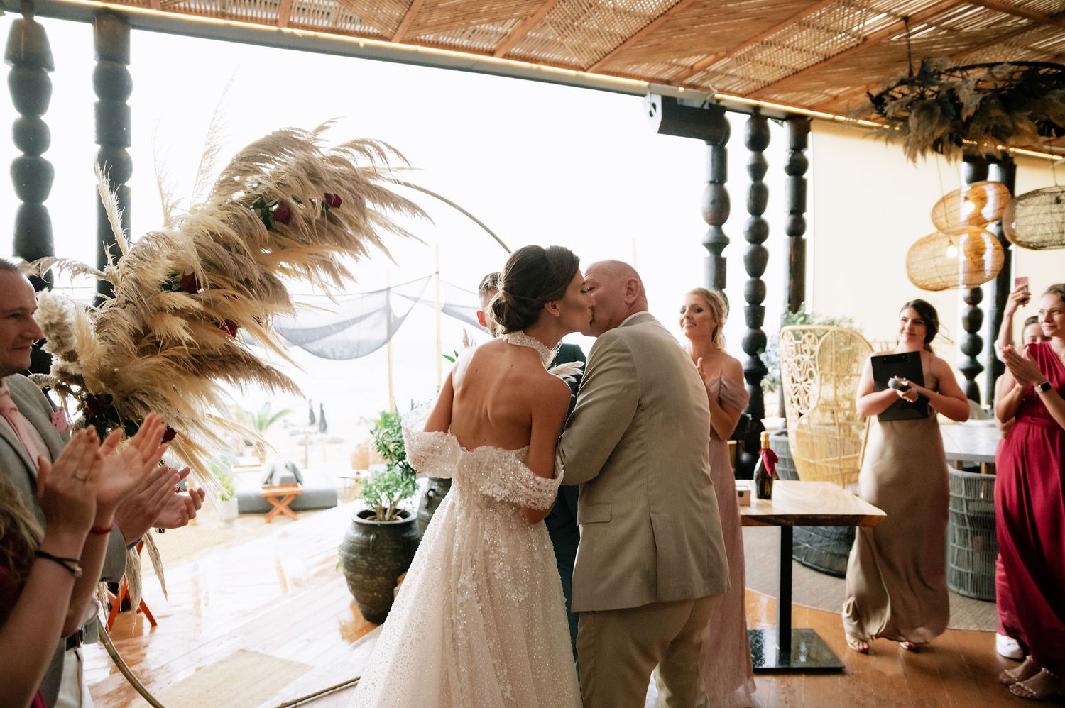 Wedding venue decorated with hanging elements and natural light streaming through windows.
