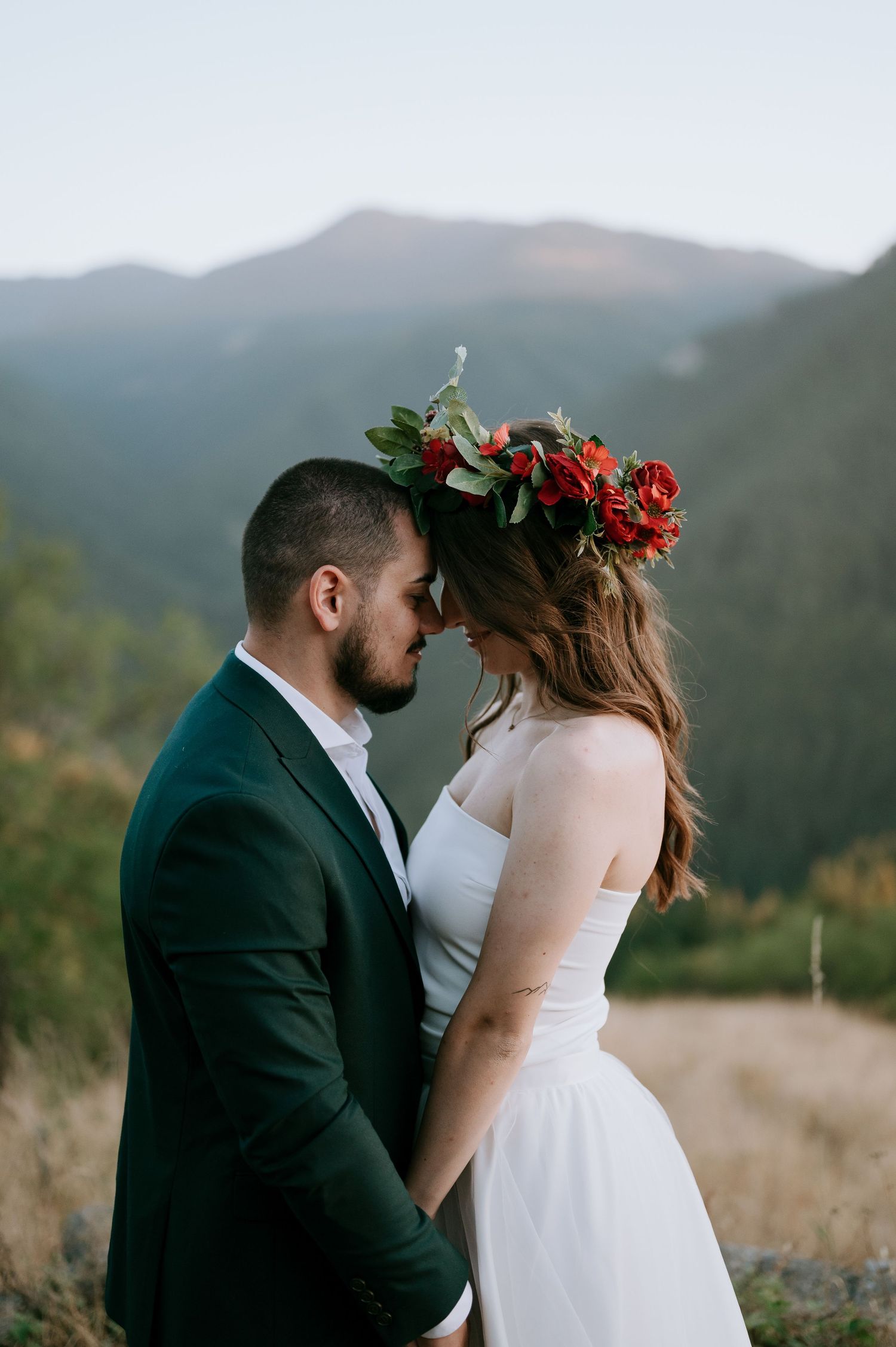 Intimate wedding portrait captured against a scenic mountain landscape.