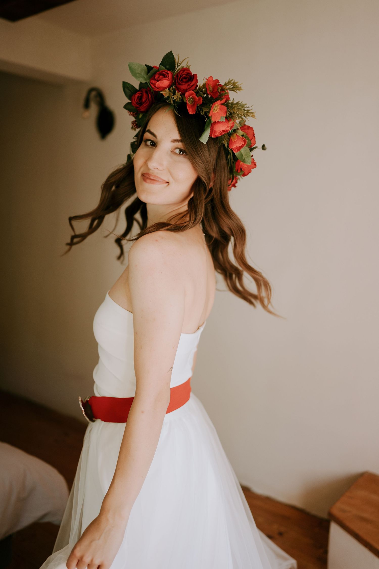 Romantic bridal portrait series with red rose crown and flowing white gown.