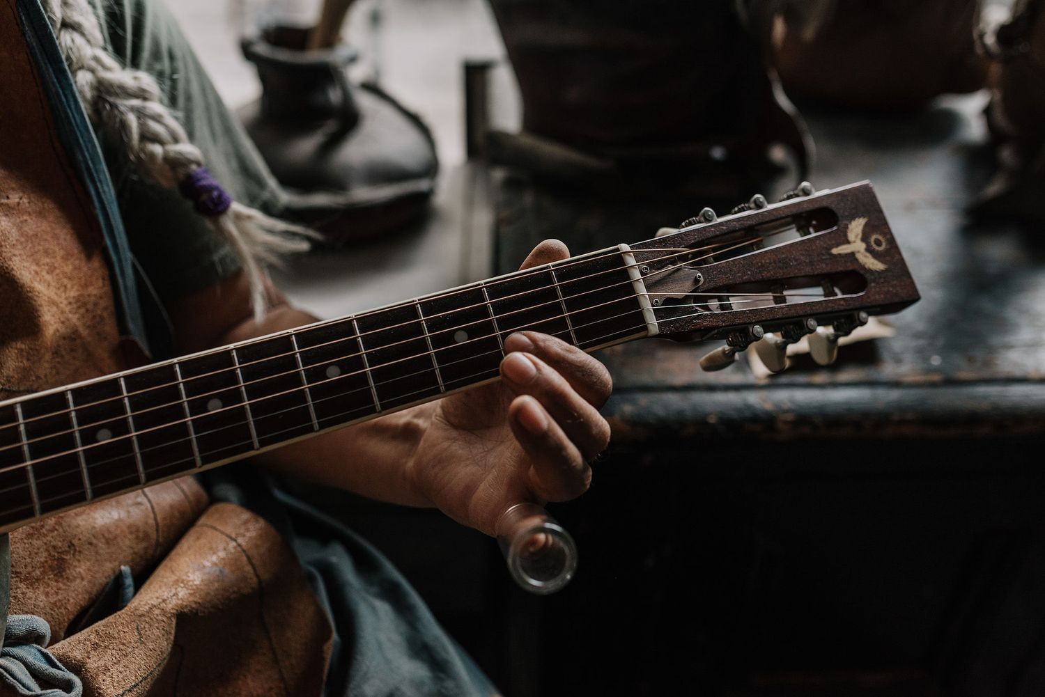 Detailed view of hands strumming an acoustic guitar's strings.