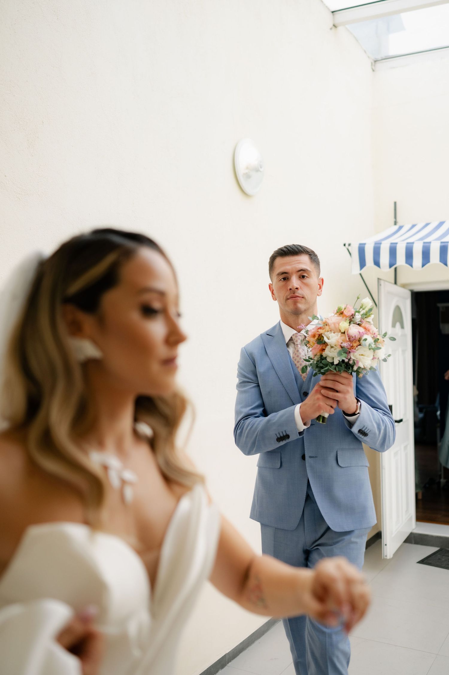 A series of wedding photos showing emotional first look moments in a light-filled indoor setting.