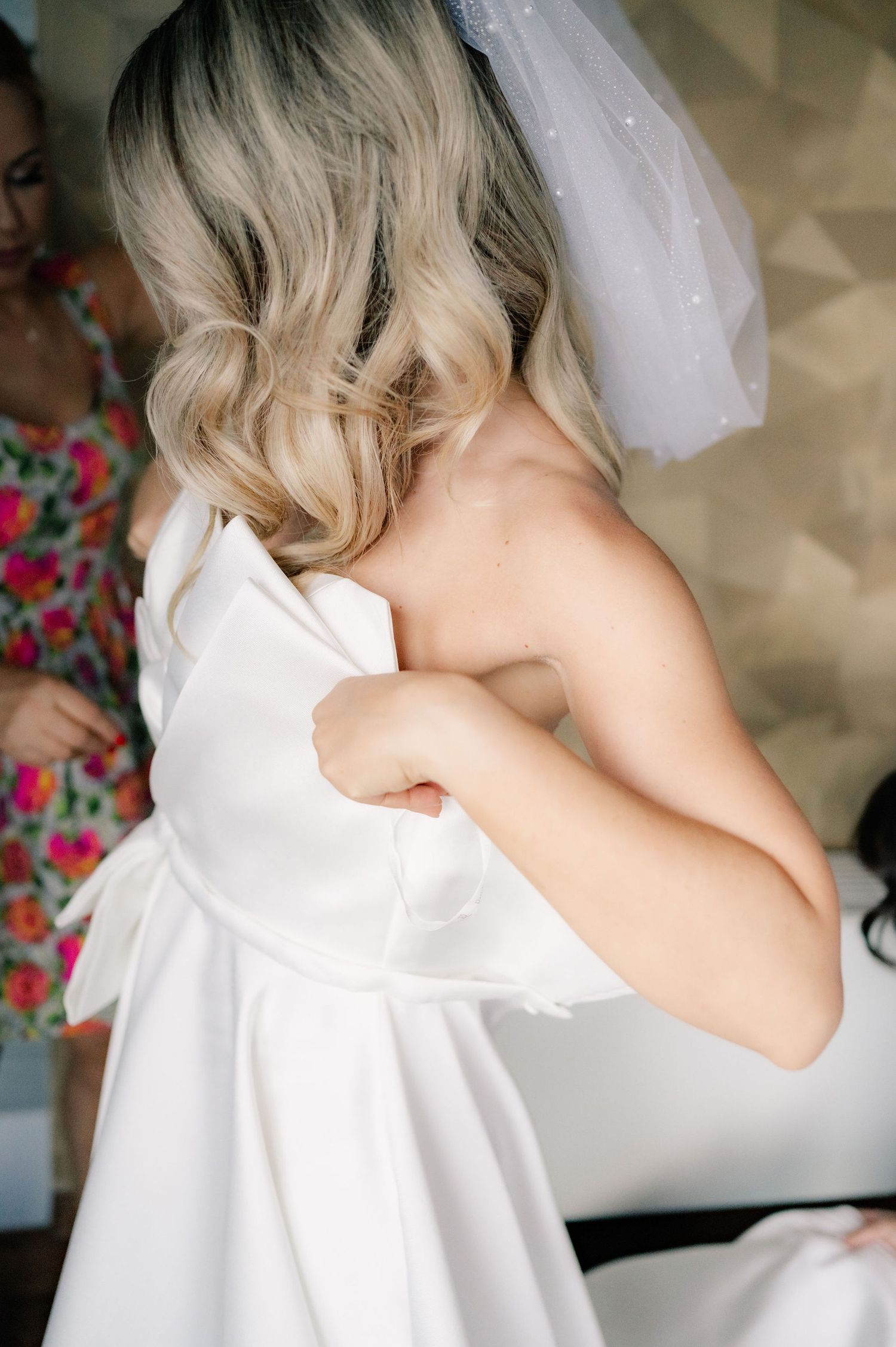 A series of photos showing a white wedding dress being fitted and adjusted during a bridal preparation session.